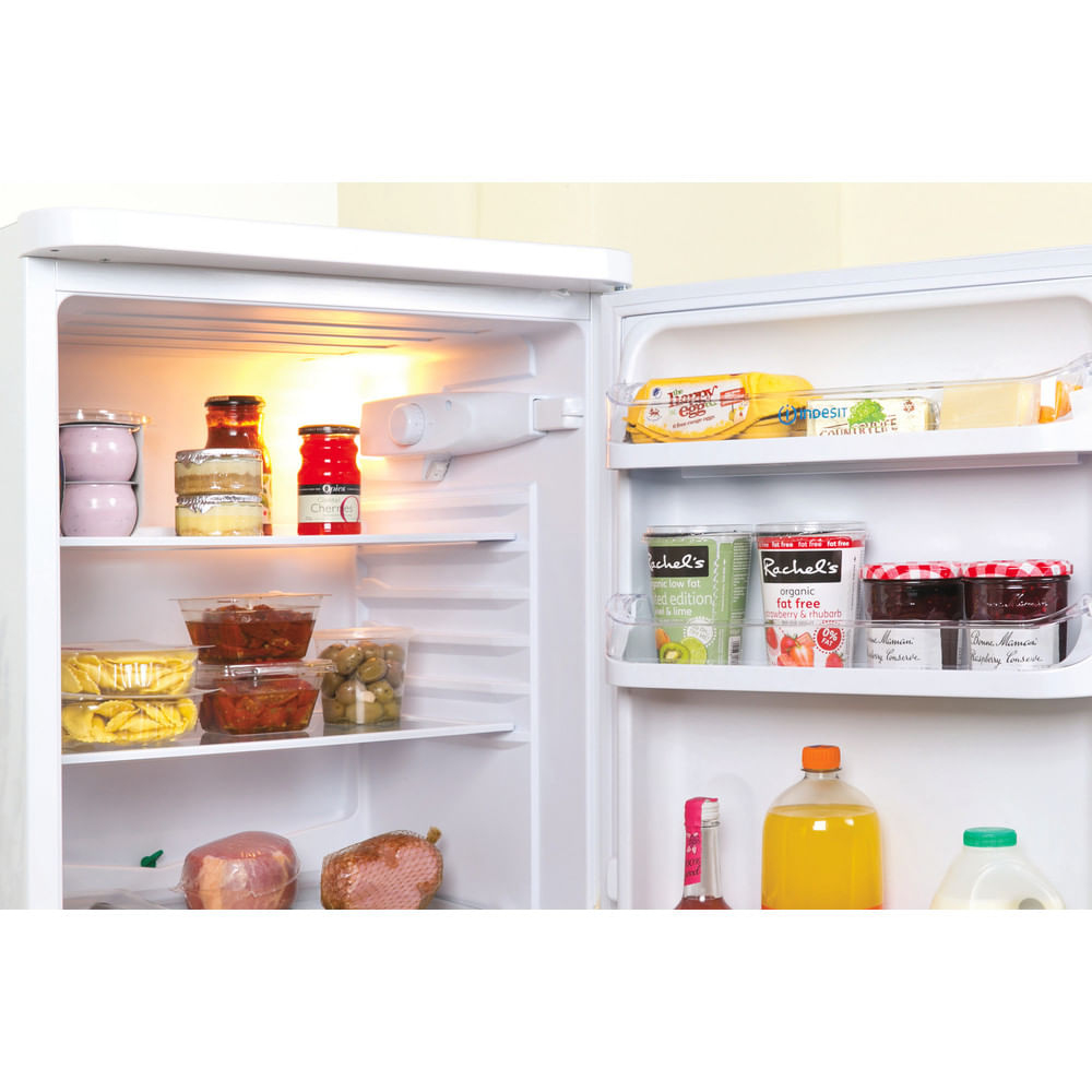 Interior del frigorífico. Varios alimentos en los estantes. Se ven tarros, queso y alimentos envasados.