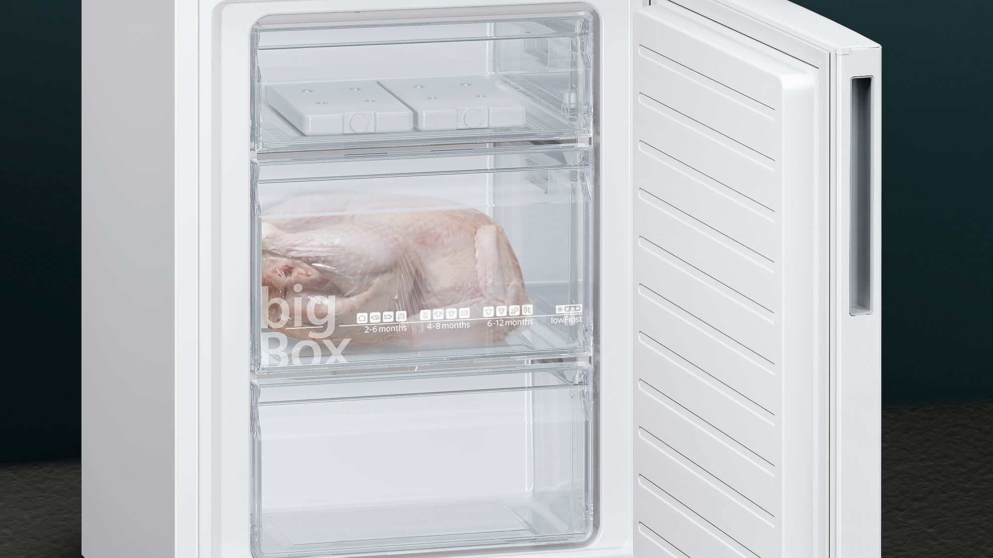 Scomparto congelatore di un frigorifero. Aperto, mostra cibo congelato nei cassetti e ghiaccio sopra.