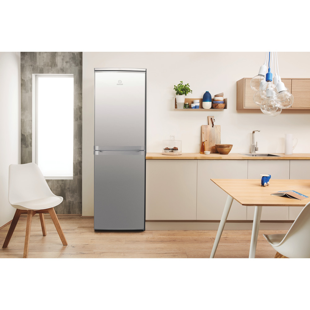Cocina con frigorífico InDésit. Mesa, silla y decoración en el fondo.