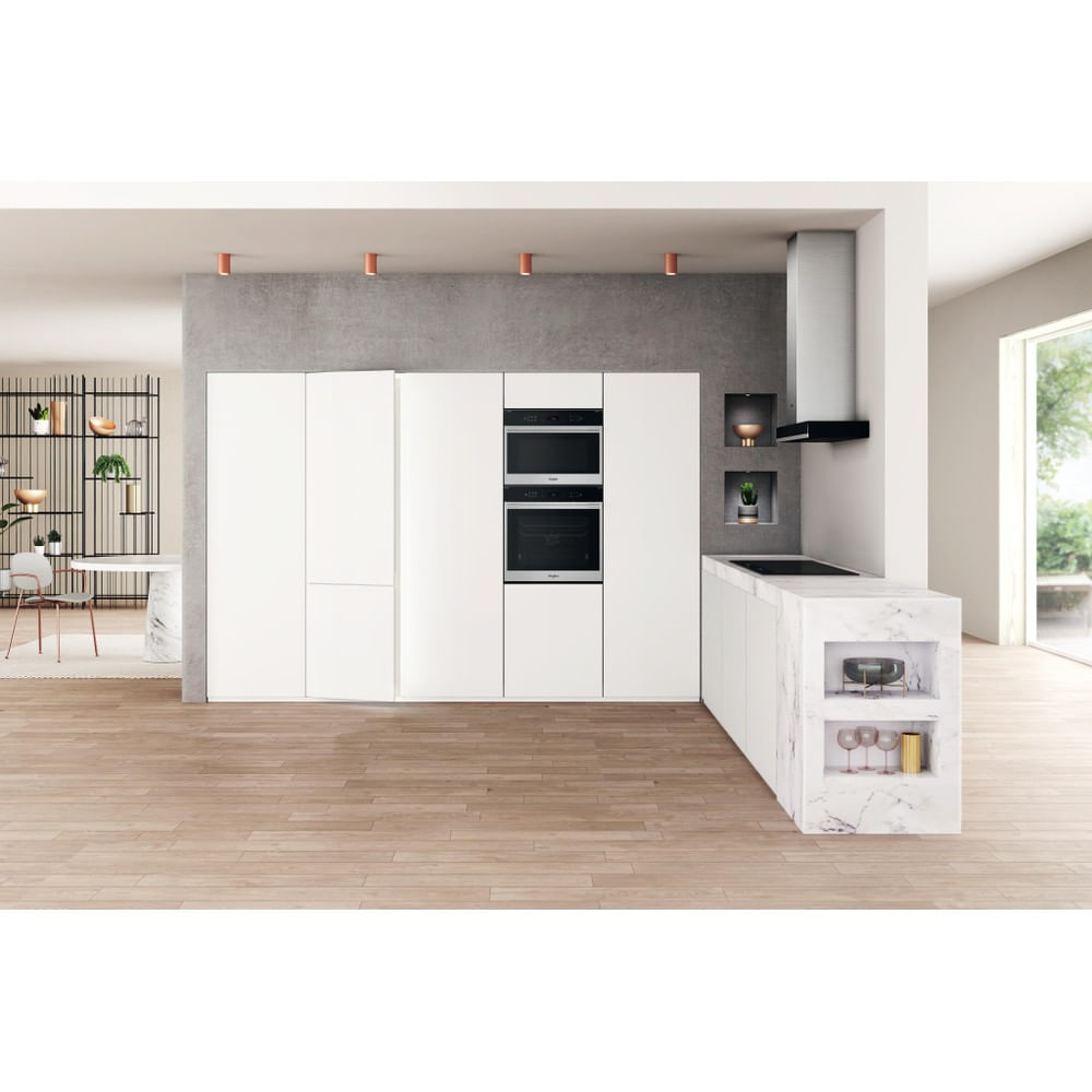 Cocina blanca moderna con electrodomésticos empotrados. Incluye horno, frigorífico e isla con encimera de mármol.