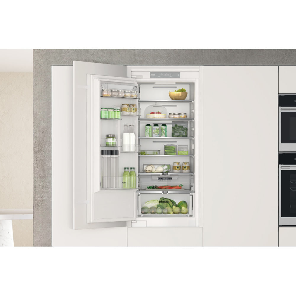 Un refrigerador con puertas abiertas, mostrando el interior. Muchos artículos son visibles en los estantes.