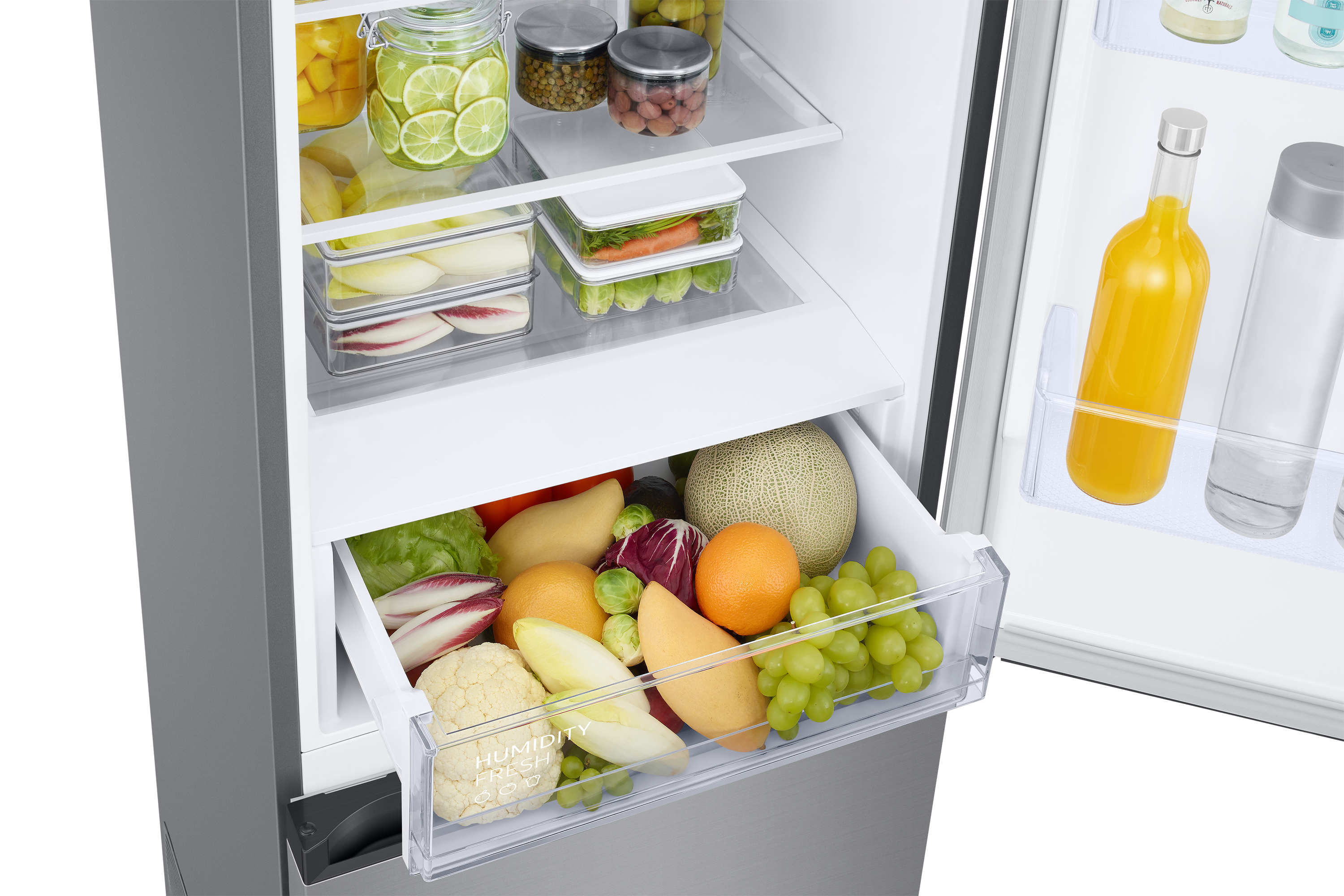 Interior del refrigerador con frutas, verduras y frascos en cajones y estantes abiertos.