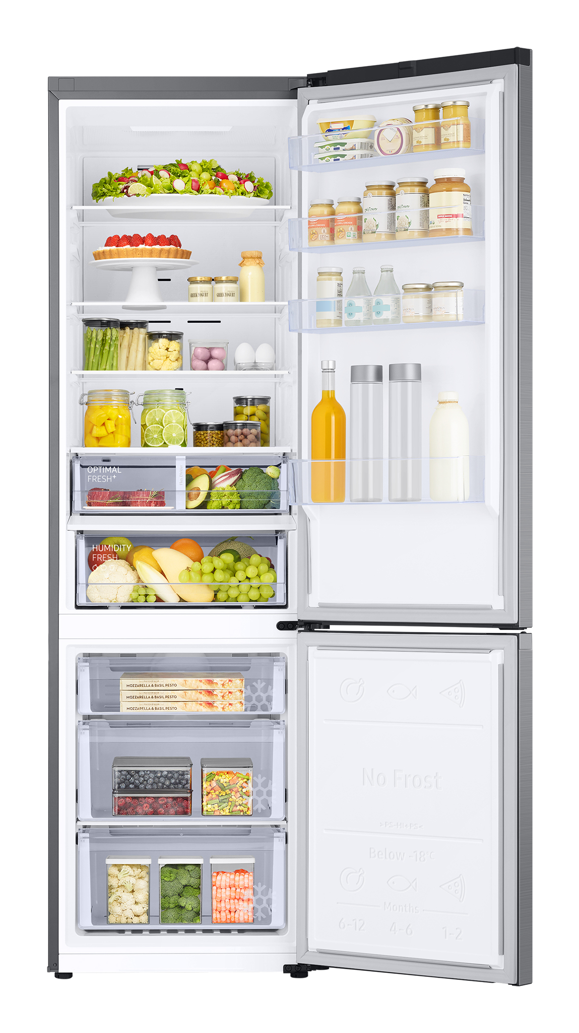 Geöffneter Kühlschrank mit Lebensmitteln. Schubladen unten. Regale mit Gläsern, Flaschen und Früchten.