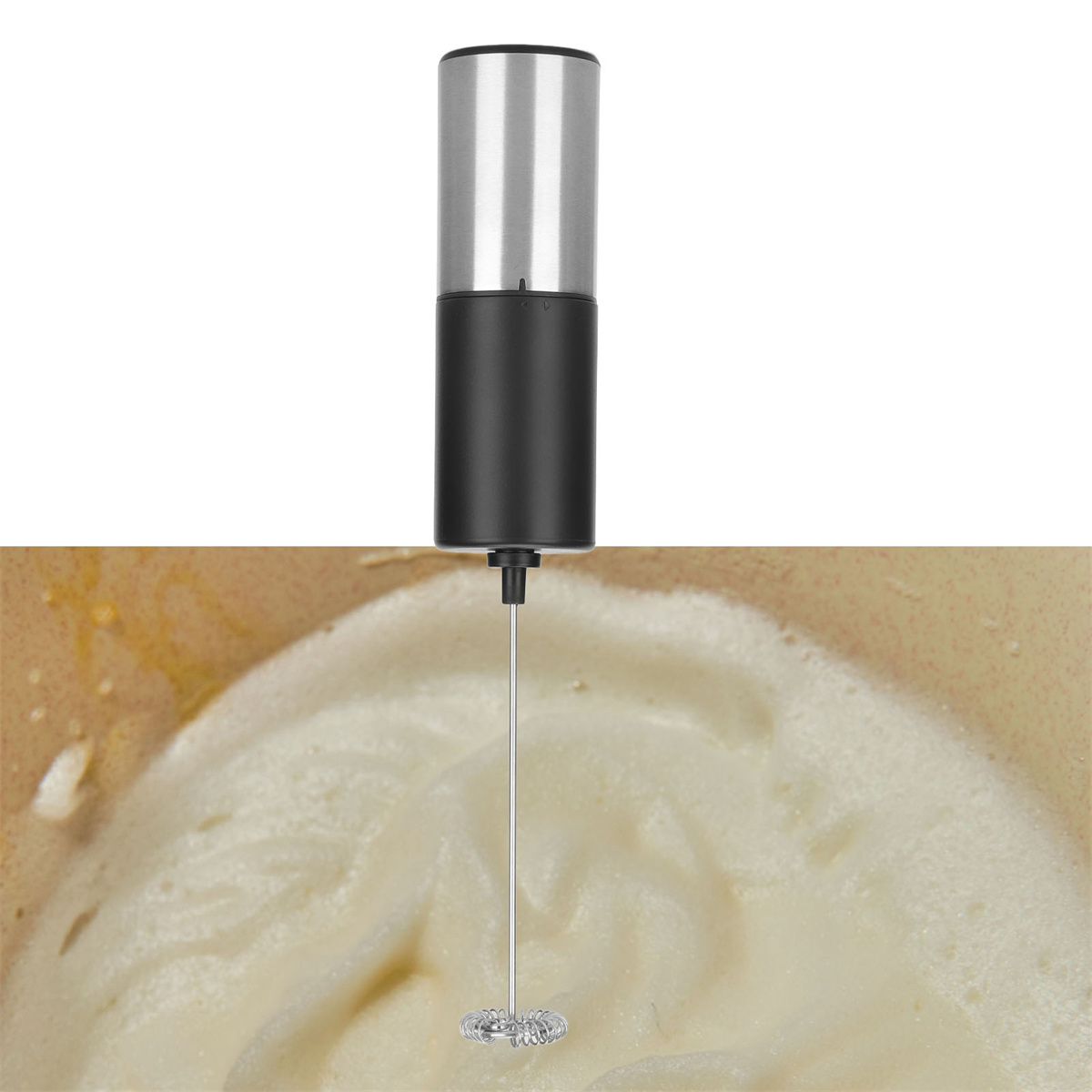 Handmilchaufschäumer, der Milch in einer Schüssel aufschäumt. Der Aufschäumer ist silber und schwarz. Beige Schüssel und weißer Schaum.