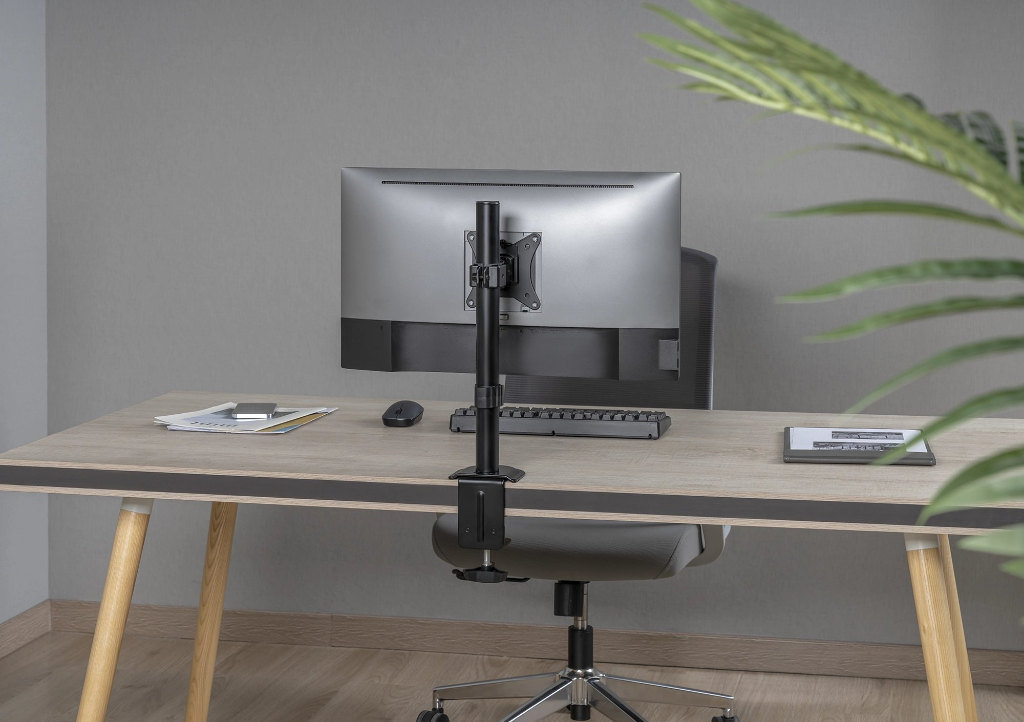 Scrivania con supporto per monitor. Monitor, tastiera, mouse e tablet sulla scrivania.