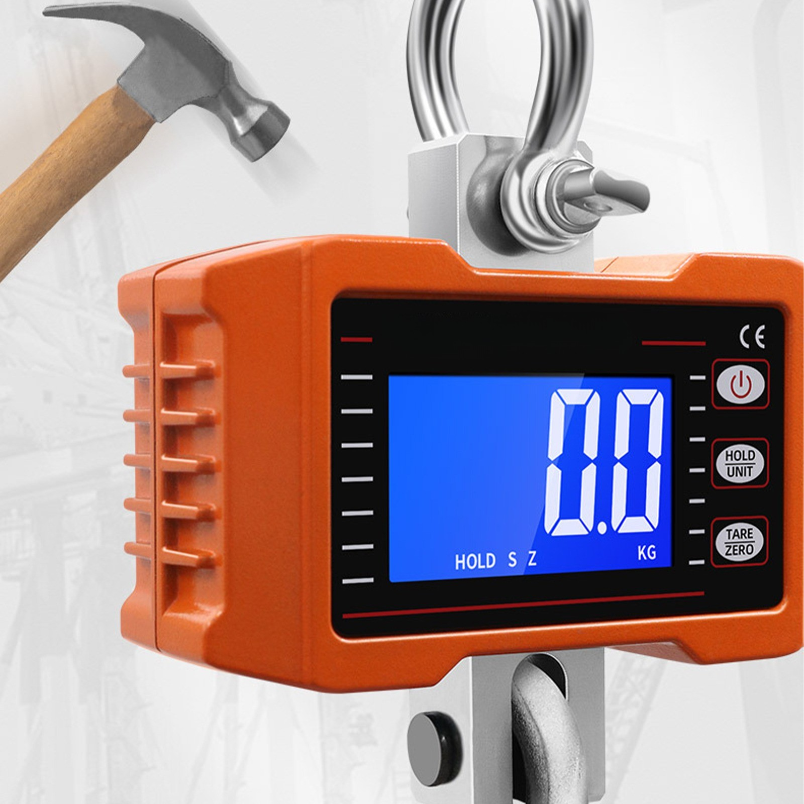 Orange Industrie-Hängewaage mit blauem Digitaldisplay, das 0,0 kg anzeigt. Ein Hammer im Hintergrund.