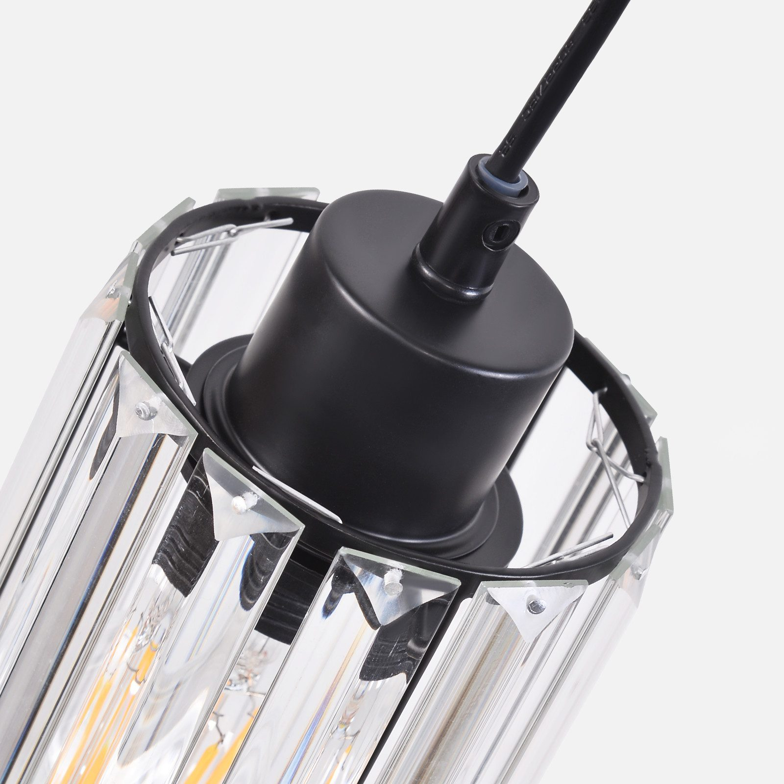 Zbliżenie kryształowej lampy wiszącej z czarnym kablem i podstawą.