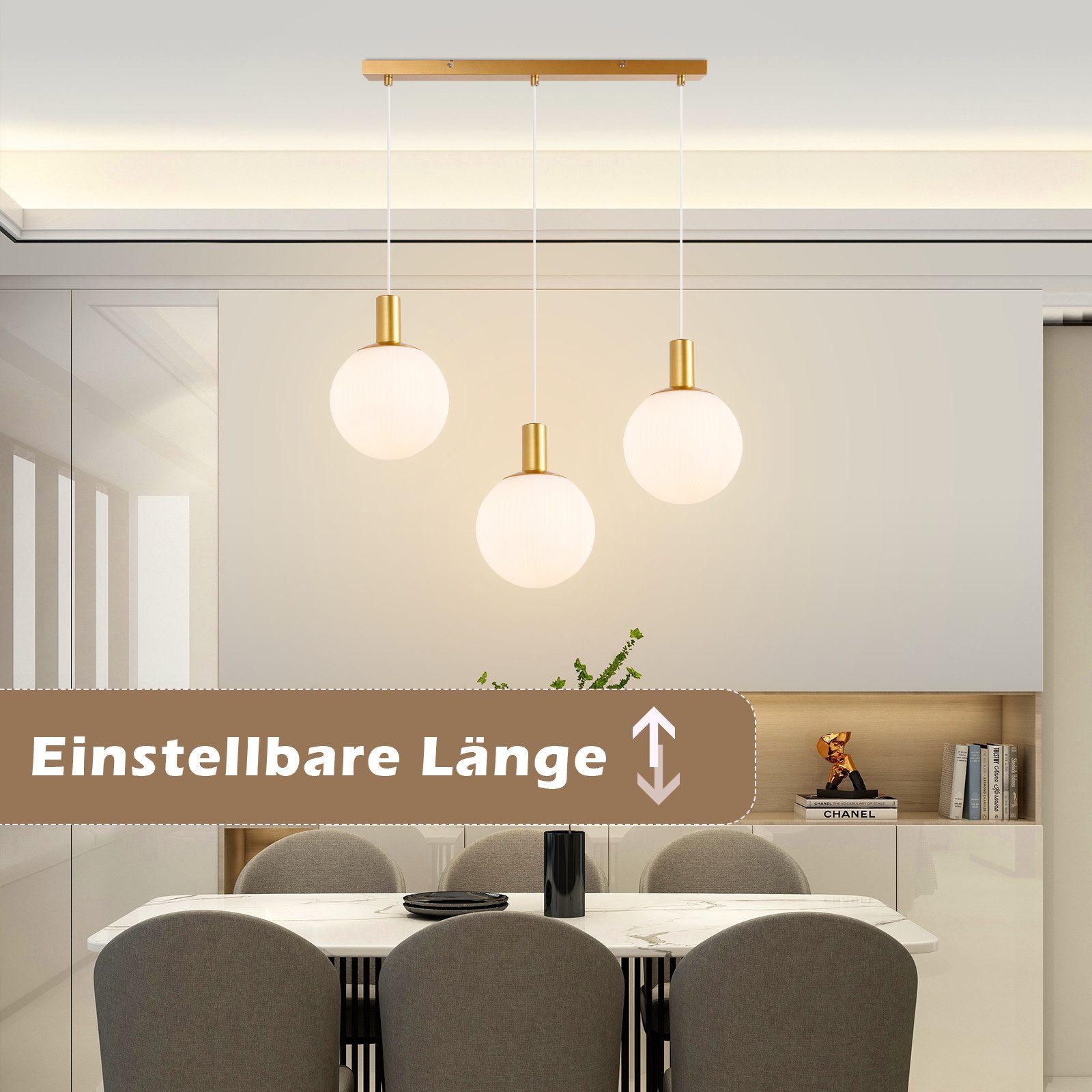 Drei Pendelleuchten mit weißen Kugelschirmen hängen von einer goldenen Stange über einem Esstisch.