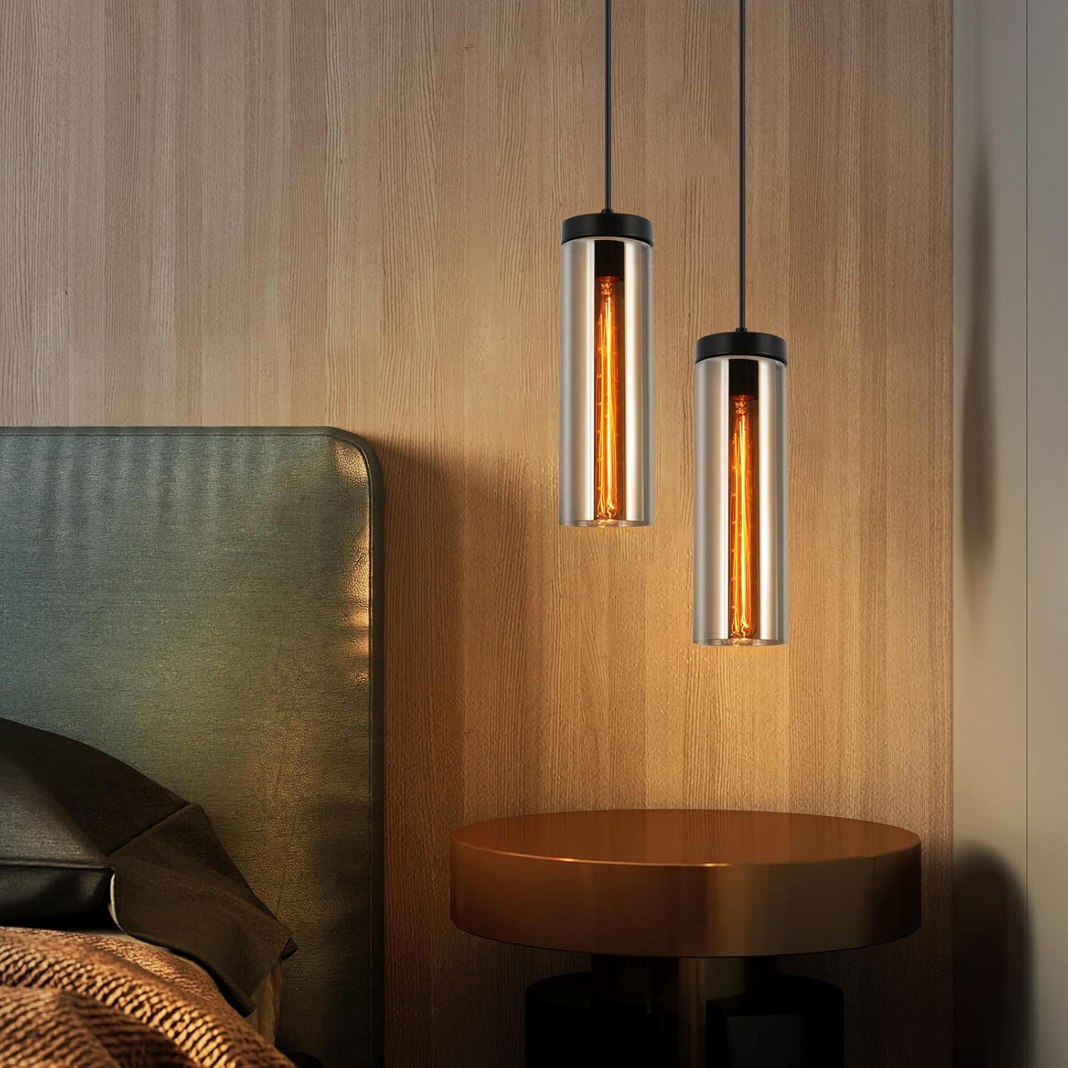 Zwei Pendelleuchten mit zylindrischen Glasschirmen, die ein Schlafzimmer mit Holzverkleidung beleuchten.