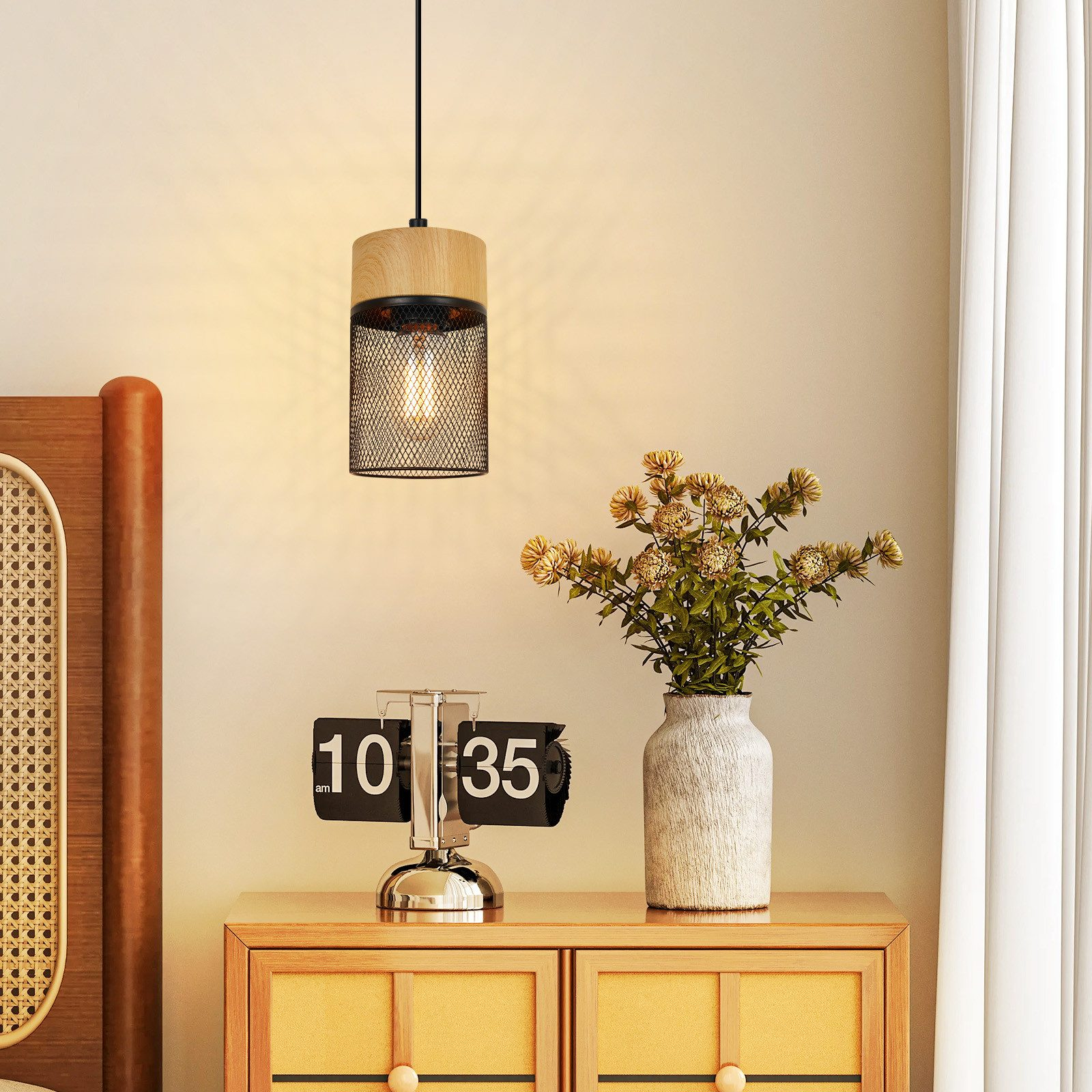 Una lampada a sospensione sopra un comodino, con un orologio digitale e un vaso di fiori nelle vicinanze.