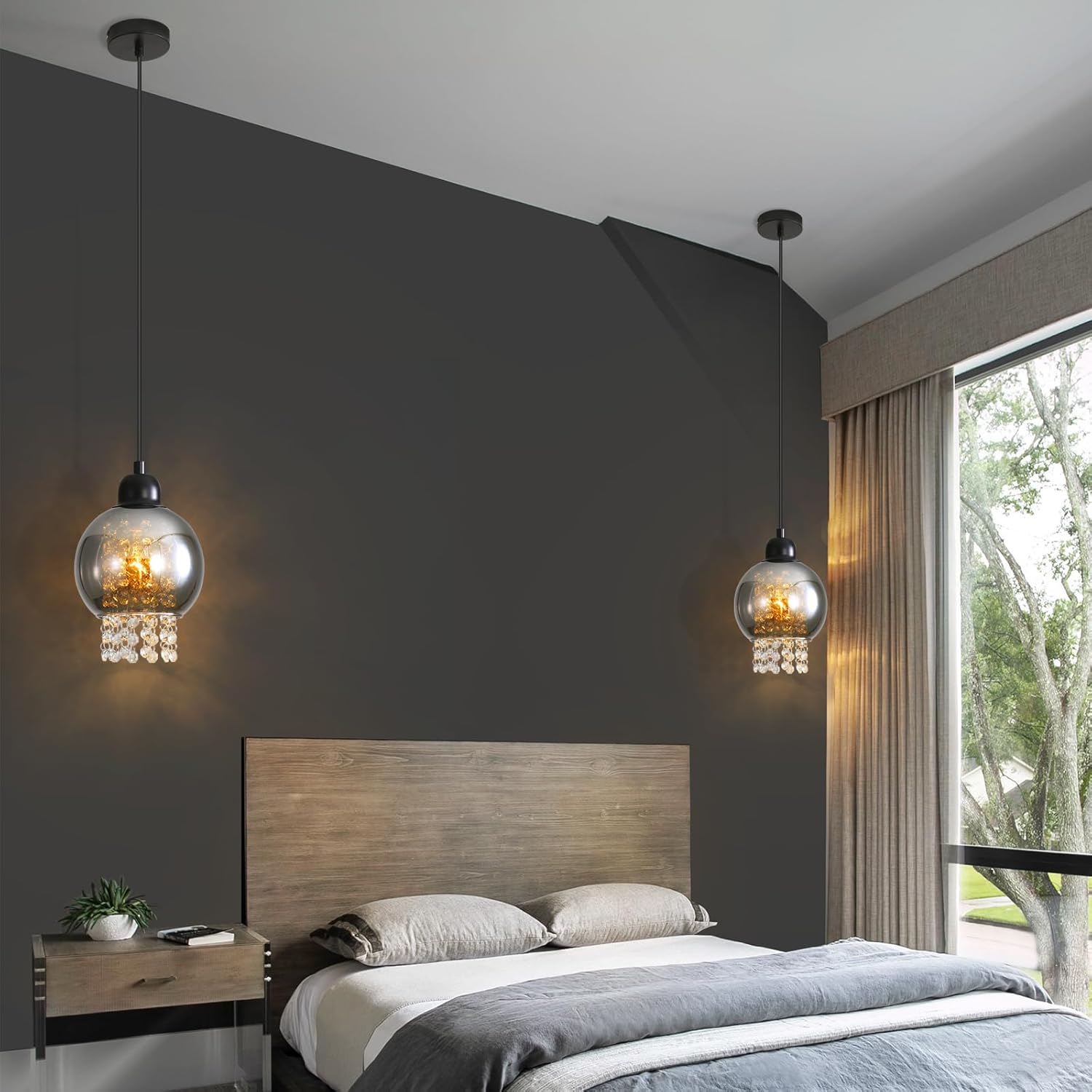 Ein Schlafzimmer mit zwei Pendelleuchten. Bett und Nachttisch im Vordergrund. Dunkelgraue Wand im Hintergrund.