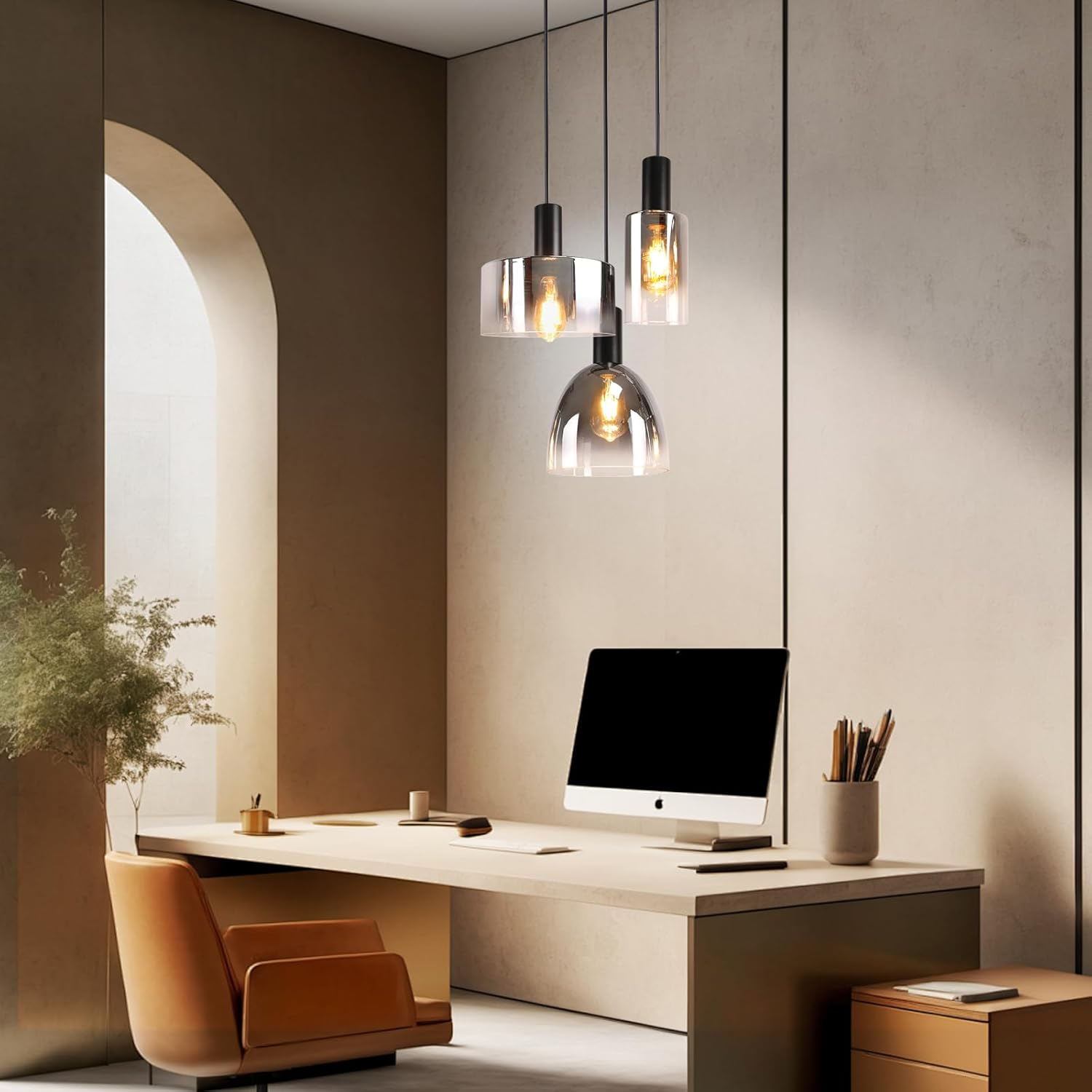 Büro mit Pendelleuchten. Drei Glas- und schwarze Leuchten hängen über einem Schreibtisch.