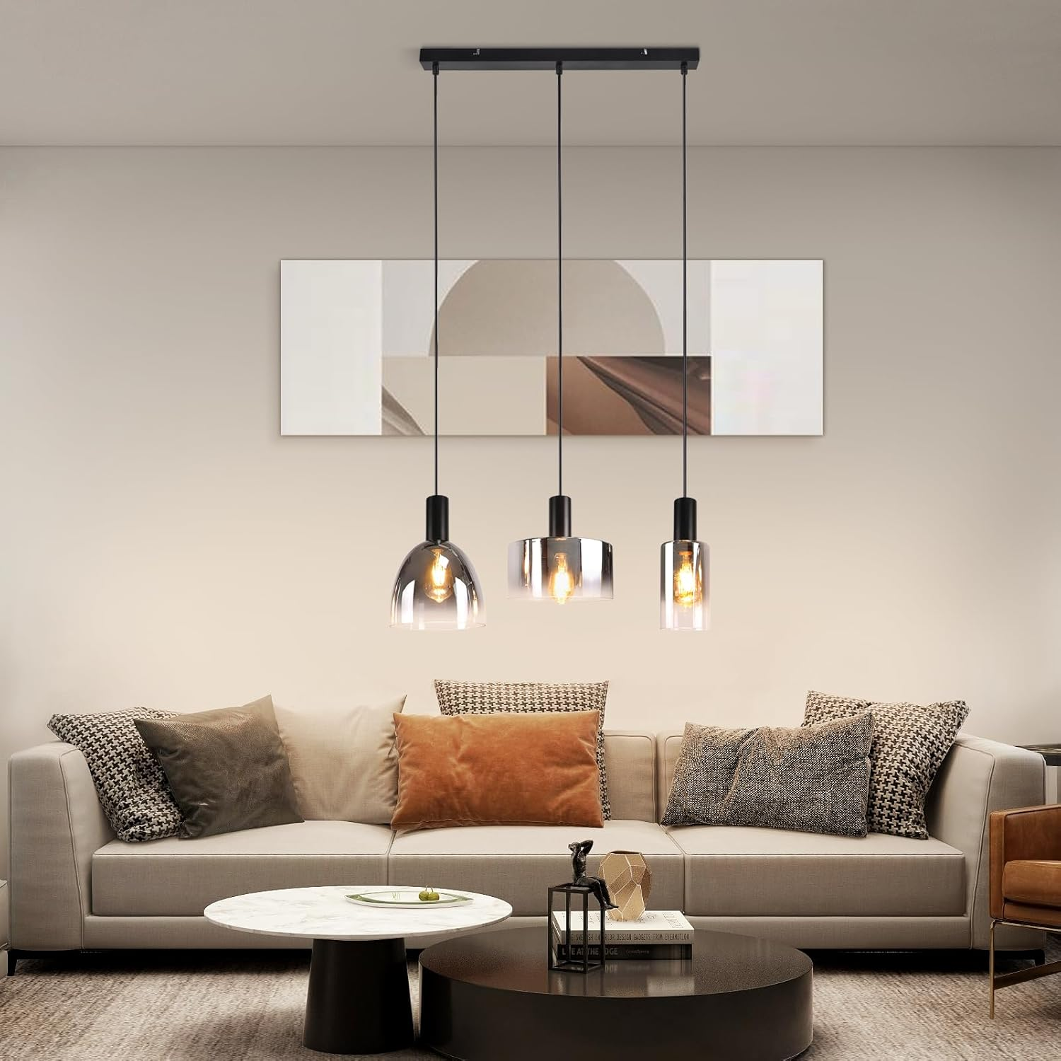Wohnzimmer mit Sofa, Kunstwerk und drei Glas-Pendelleuchten.