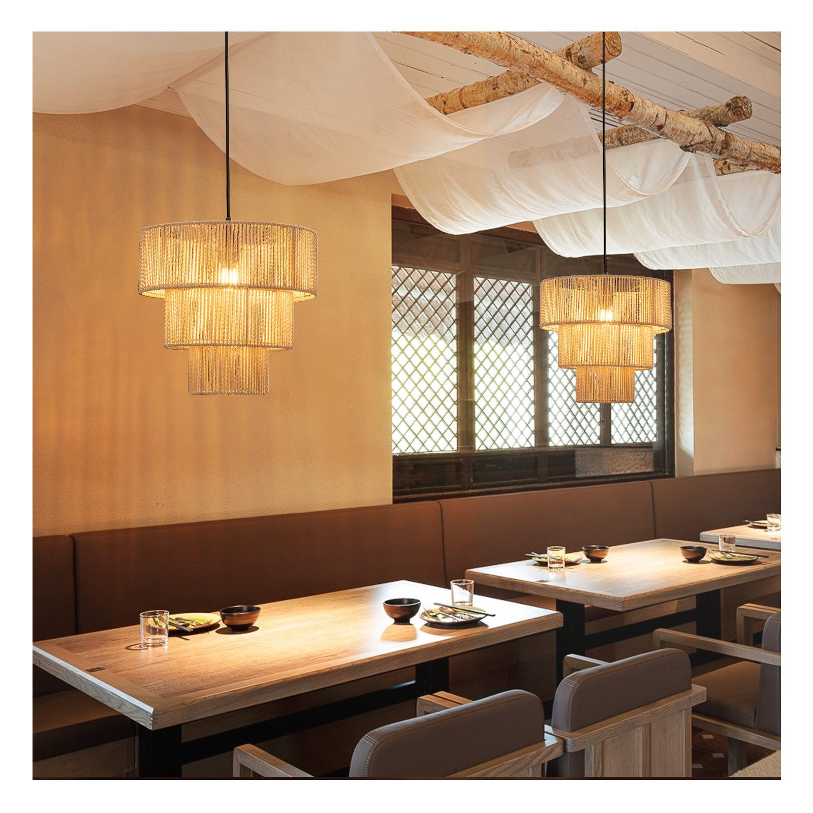 Interno di un ristorante con lampade a sospensione, tavoli e sedie. Dominano i toni caldi.