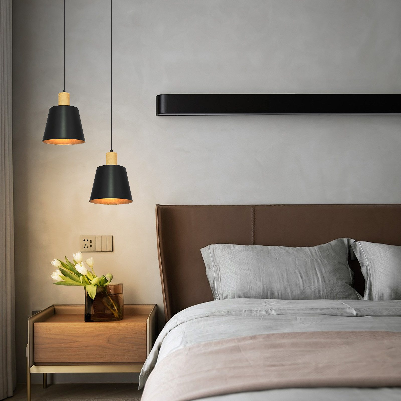 Camera da letto con lampade a sospensione su comodino e letto.