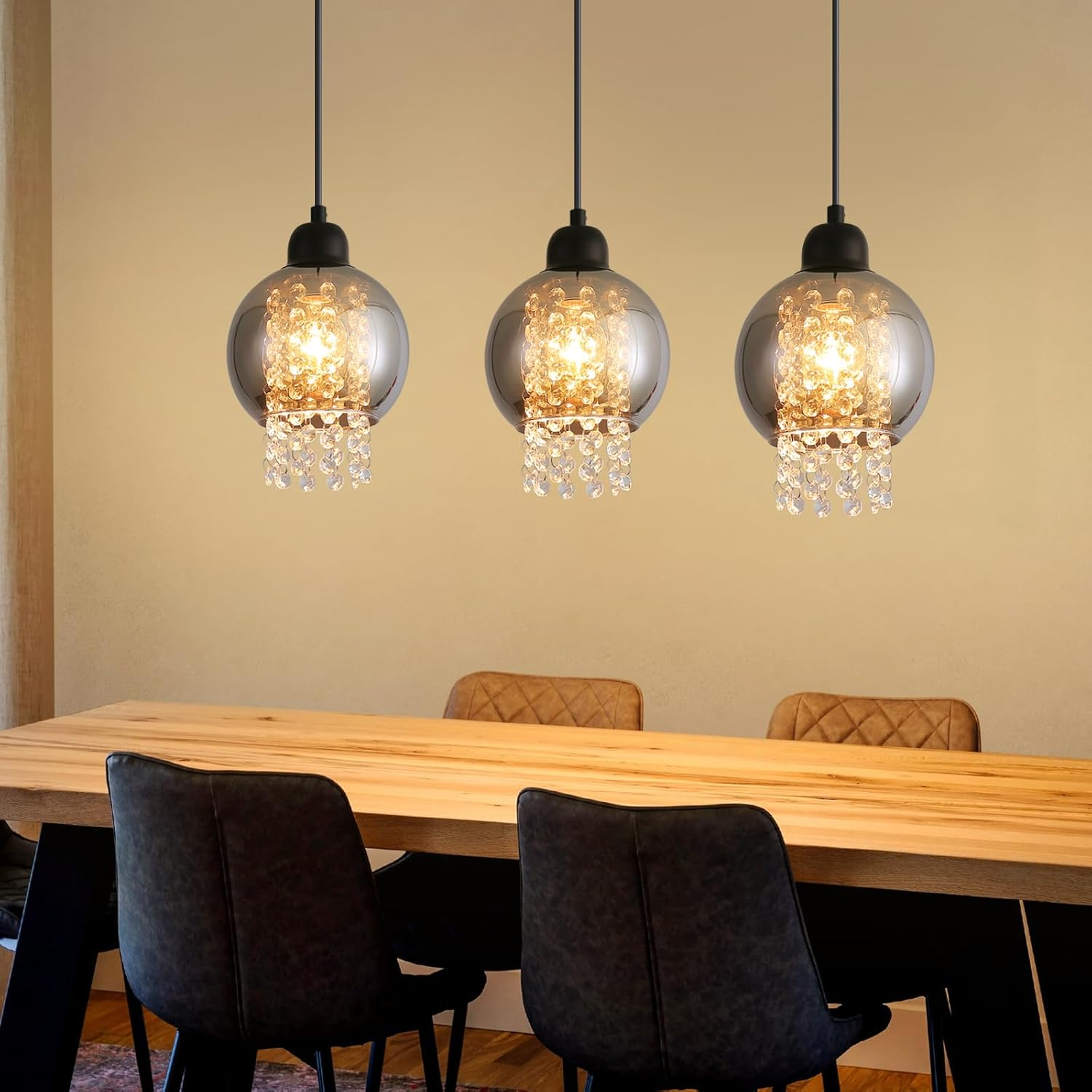 Tres lámparas colgantes con colgantes de cristal sobre una mesa de comedor.