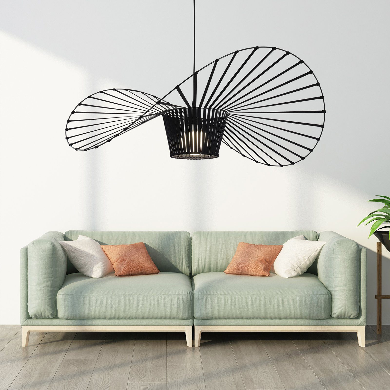 Eine moderne schwarze Deckenlampe mit einzigartigem Design, die über einem hellgrünen Sofa mit Kissen hängt.