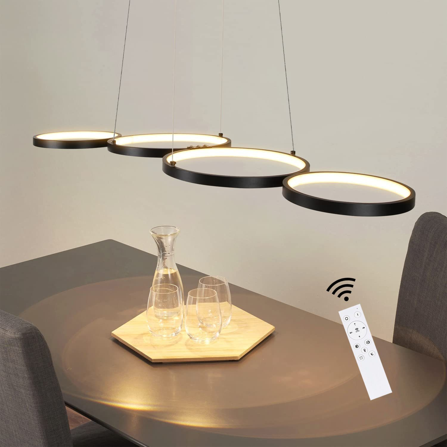 Modernes Esszimmer mit schwarzem Tisch, Gläsern und Fernbedienung.