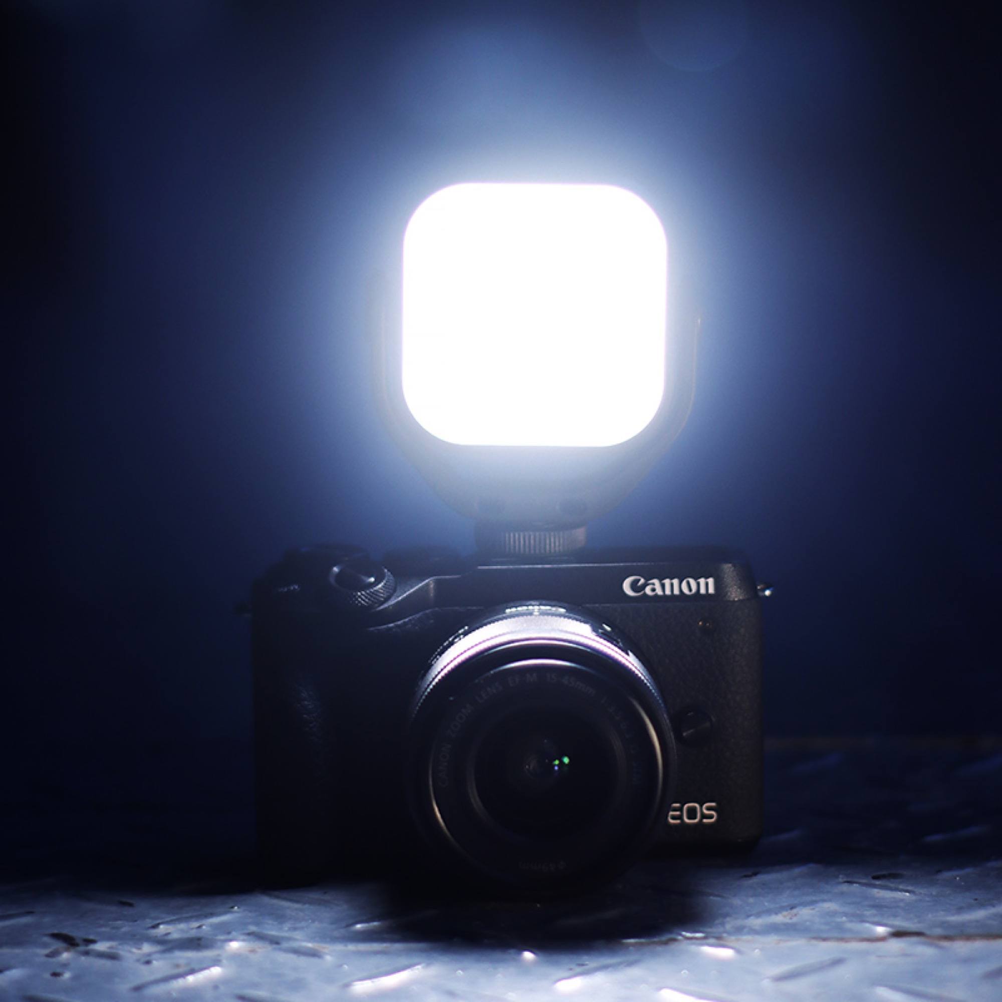Camera with a square LED light on top, shining brightly.
