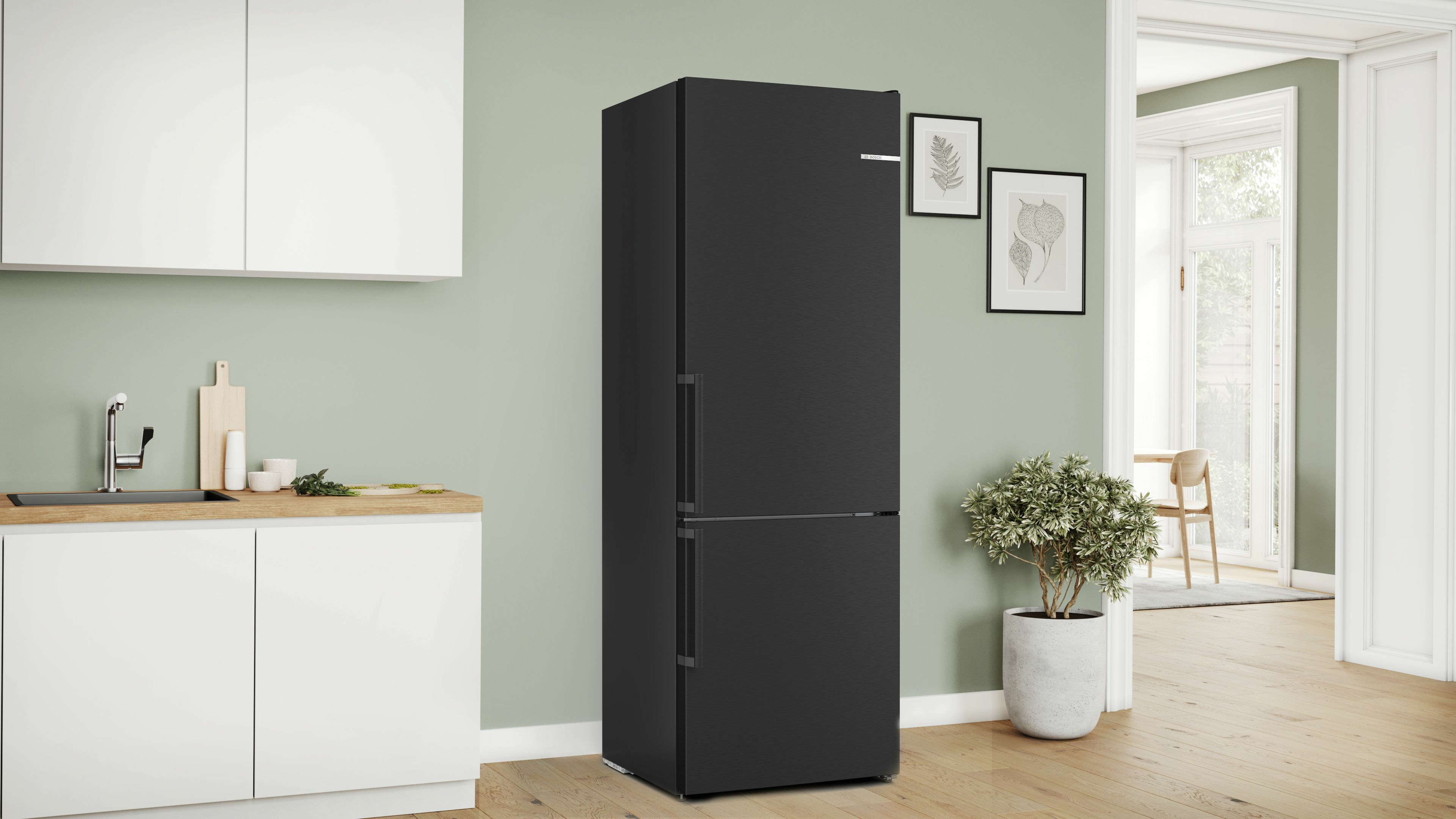 Schwarzer Kühlschrank in einer Küche mit weißer Arbeitsplatte und grüner Wand.