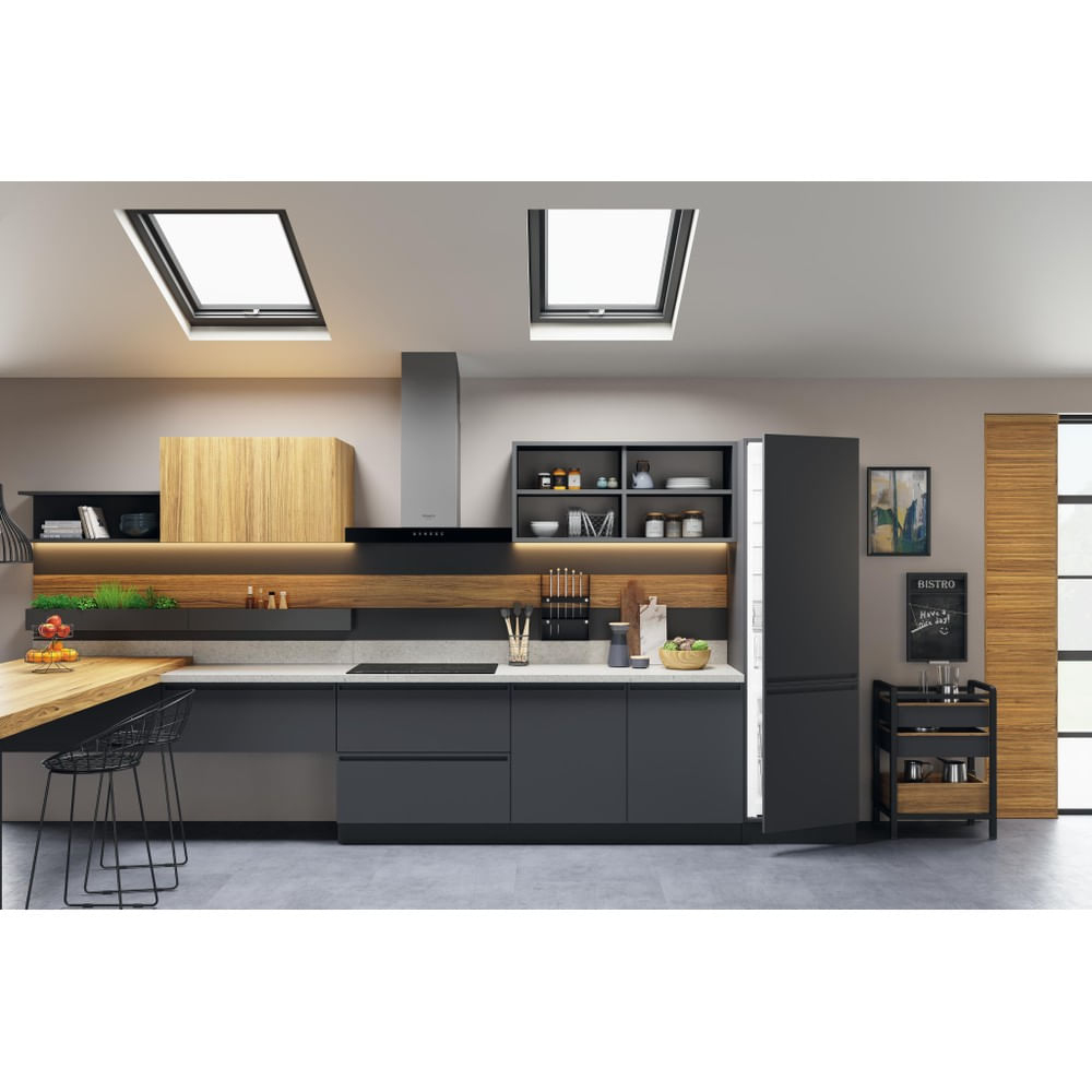 Una cucina moderna con due lucernari, un'isola grigio scuro e un frigorifero aperto.