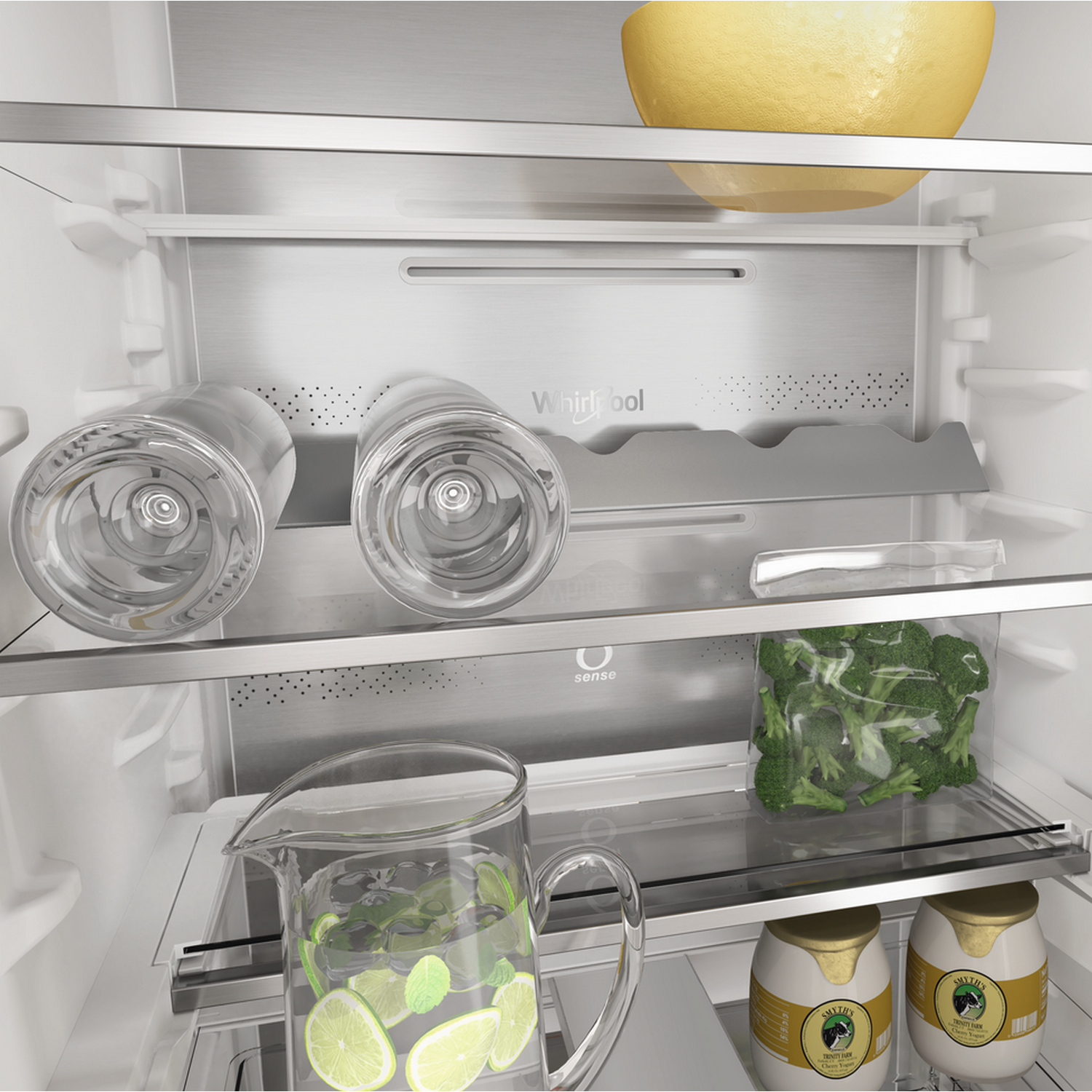 Interno del frigorifero con ripiani in vetro, brocca d'acqua con limone e sacchetto di broccoli.