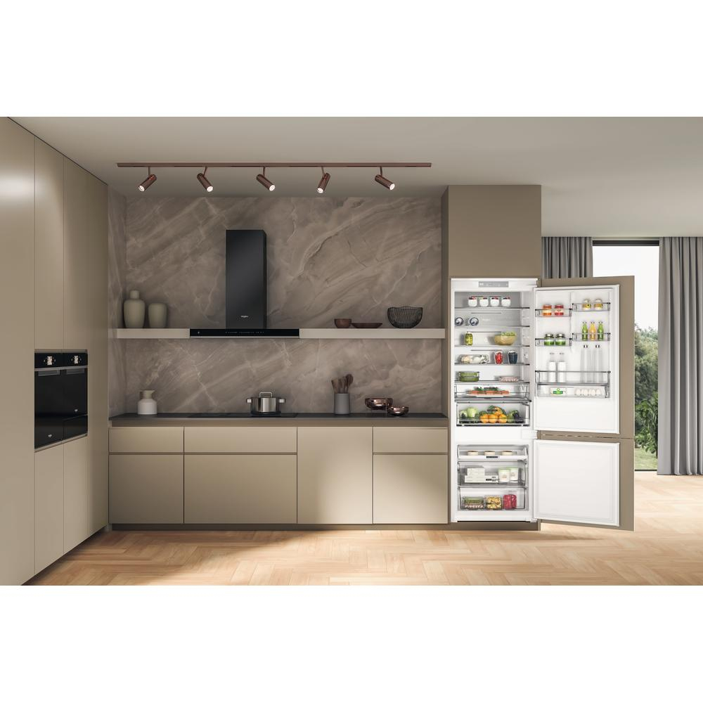 Una cucina con un frigorifero, aperto e pieno di generi alimentari.
