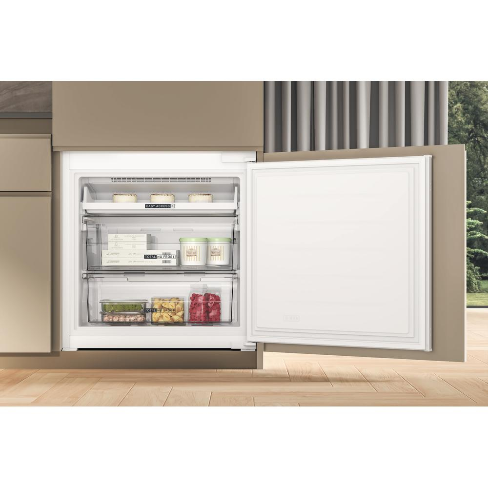Congelatore a incasso con porta aperta, mostra cassetti e contenuto. Ambiente cucina moderno.
