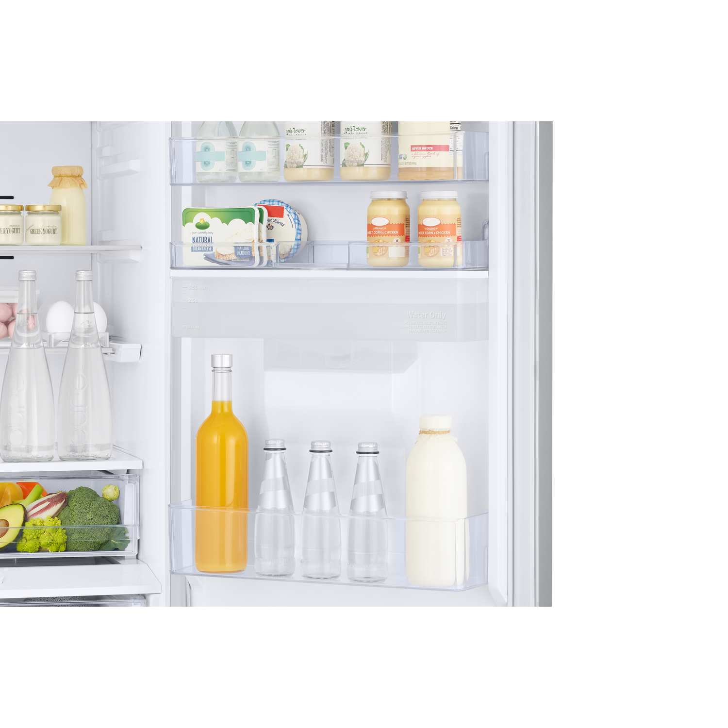 All'interno di un frigorifero. Frutta, verdura, bottiglie di latte, succo e altri alimenti sono visibili.