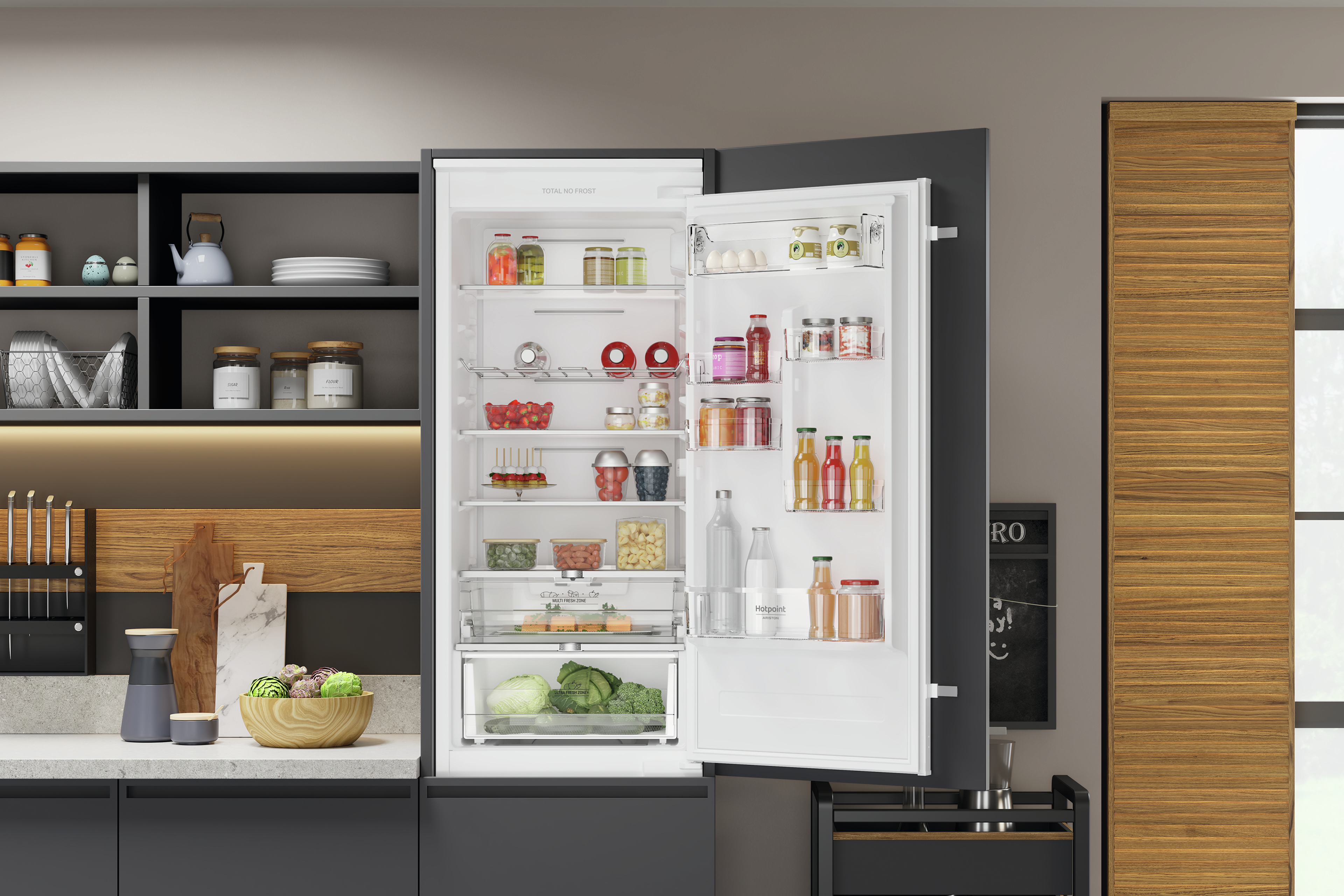 Frigorifero aperto in cucina. Gli alimenti sono all'interno. Elementi cucina grigi e in legno.