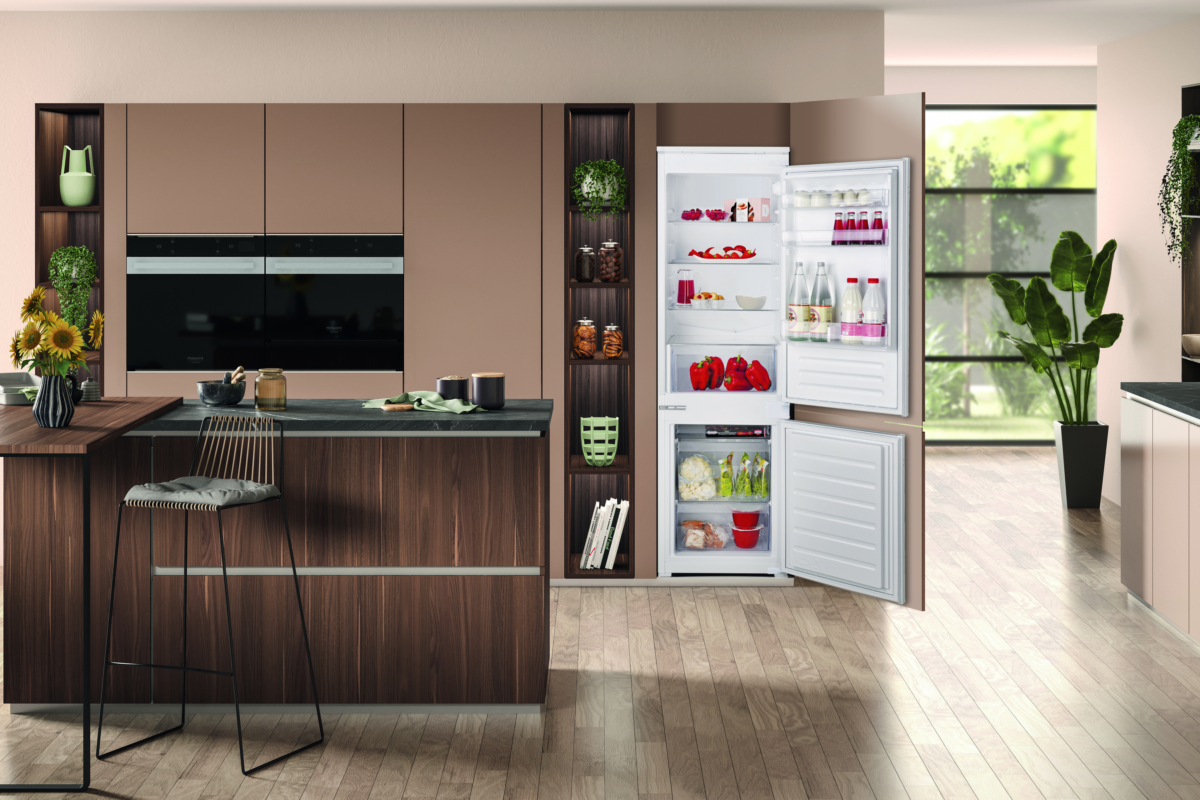 Cucina moderna con frigorifero aperto. Piena di alimenti. Isola cucina con sgabelli.