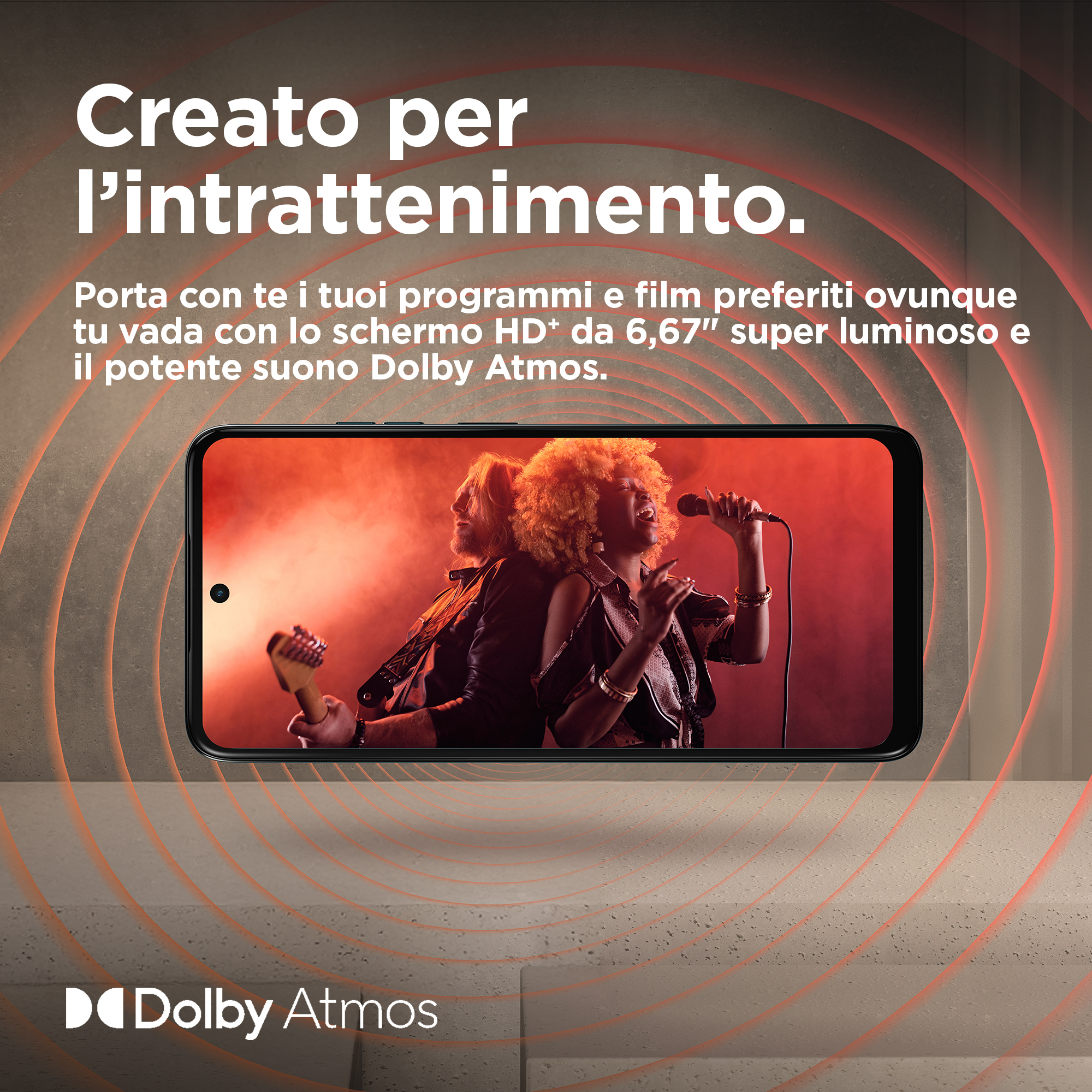 Smartfon odtwarzający wideo z koncertu. Tekst nad ekranem: Stworzony dla rozrywki. Logo Dolby Atmos.