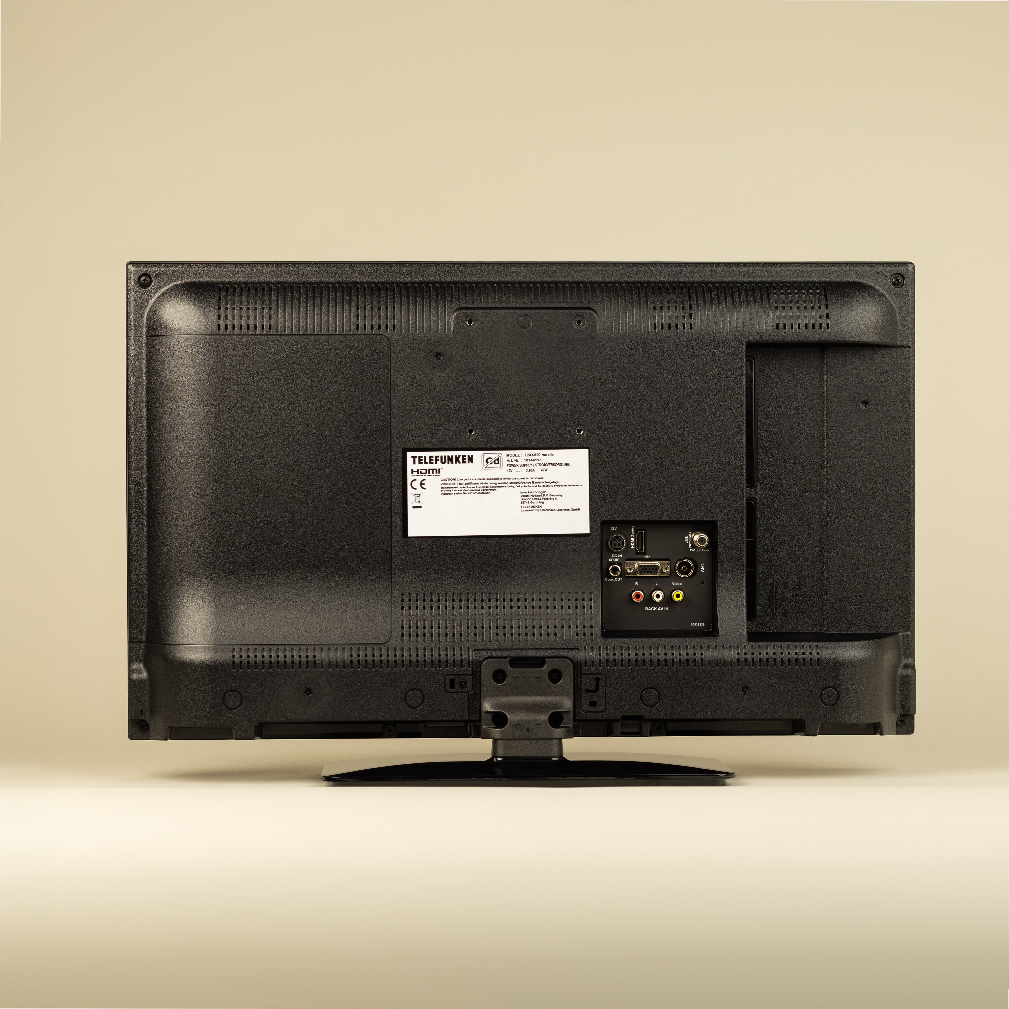 Rückansicht eines schwarzen Fernsehers mit Anschlüssen und einem Etikett.