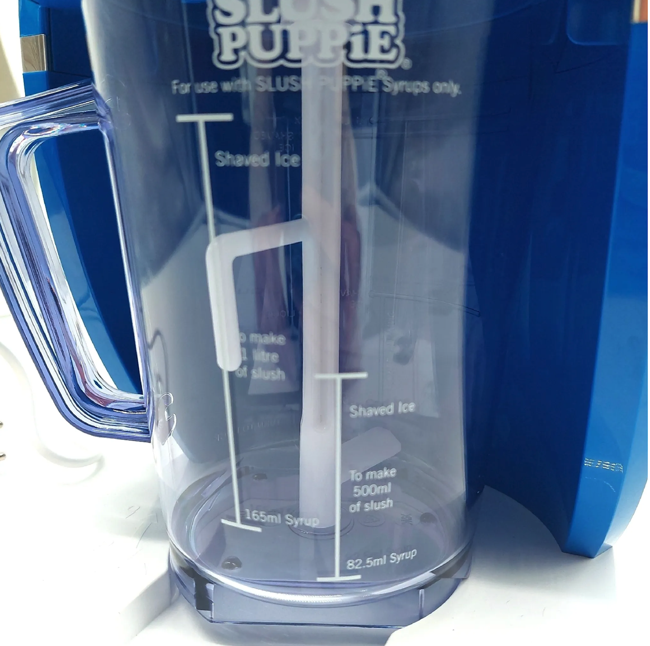 Clear slush machine with measurement lines and a blue exterior.