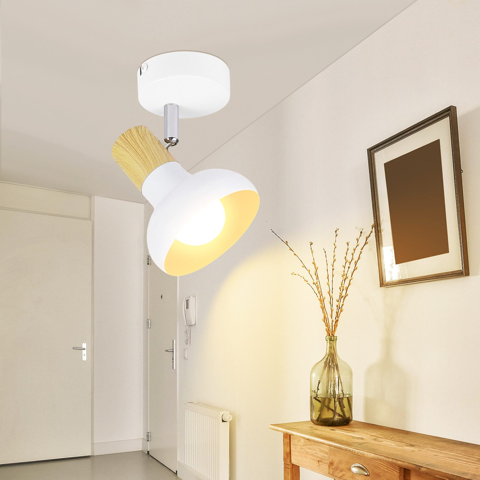 Biała lampa sufitowa z drewnianym detalem. Jest zamontowana na suficie, a obraz na ścianie.