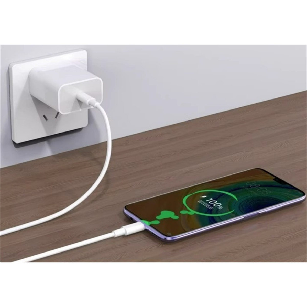 Ein Telefon, das von einem weißen Kabel und Ladegerät geladen wird, das an die Wand angeschlossen ist. Telefon ist bei 100%.