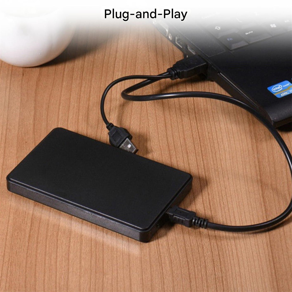 Schwarze externe Festplatte, per USB-Kabel mit Laptop verbunden.