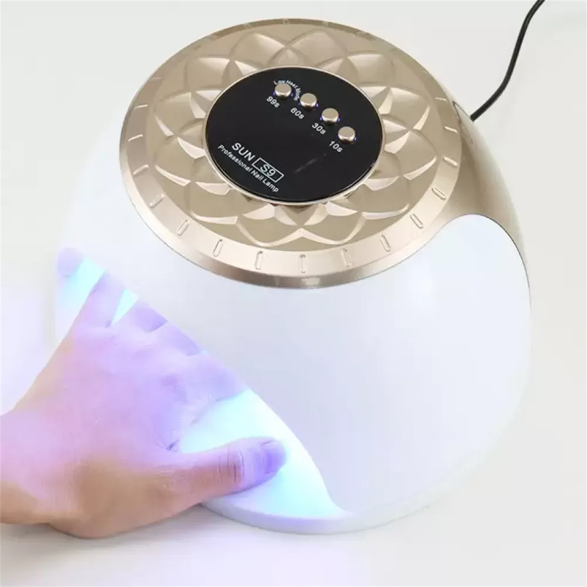 Hand mit lackiertem Nagel in einem weißen Nagellacktrockner mit Timern.
