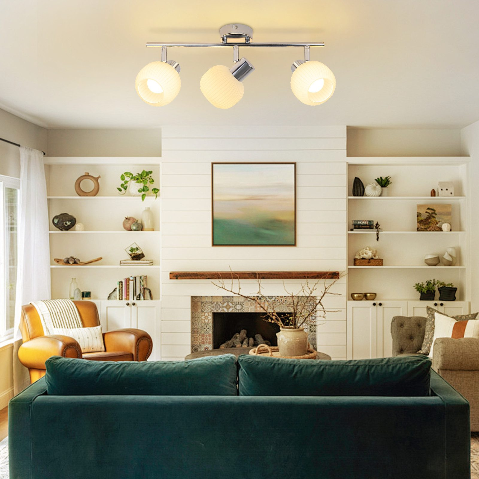 Salon z zieloną sofą, kominkiem i trzypunktowym oświetleniem szynowym na suficie.