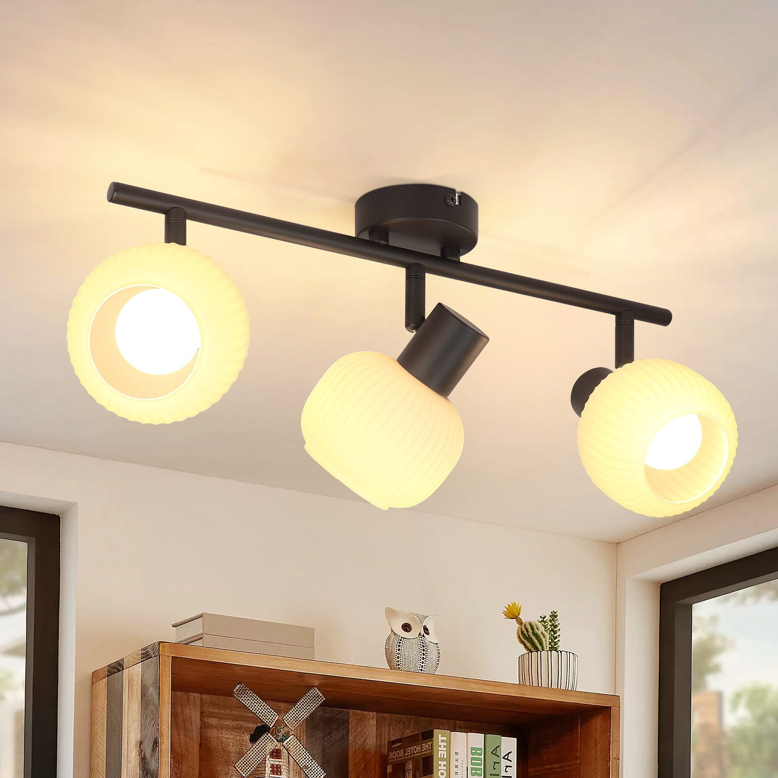 Oprawa oświetleniowa sufitowa z trzema regulowanymi światłami, na jasnym suficie.
