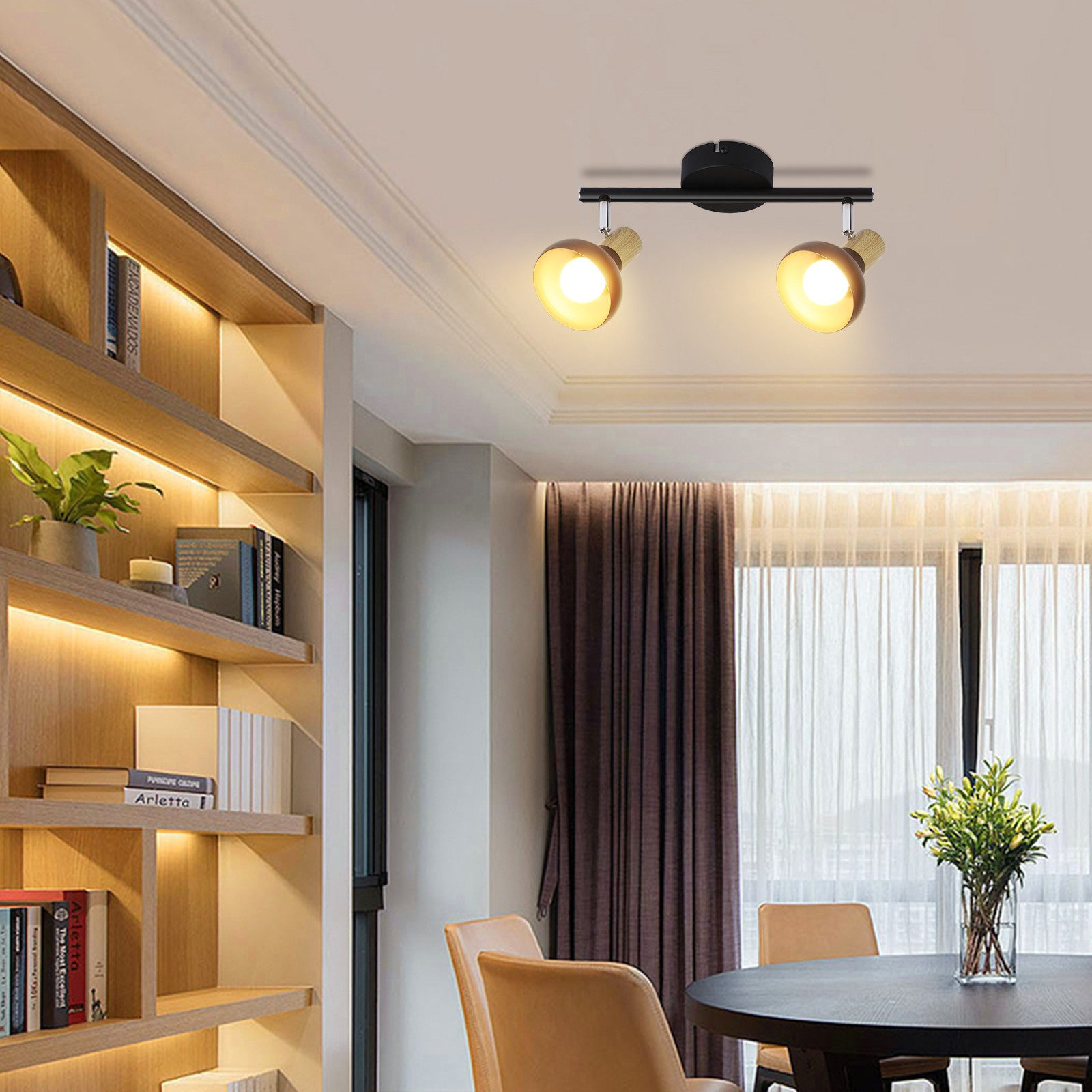 Oświetlenie sufitowe nad stołem i krzesłami w pokoju z regałami.