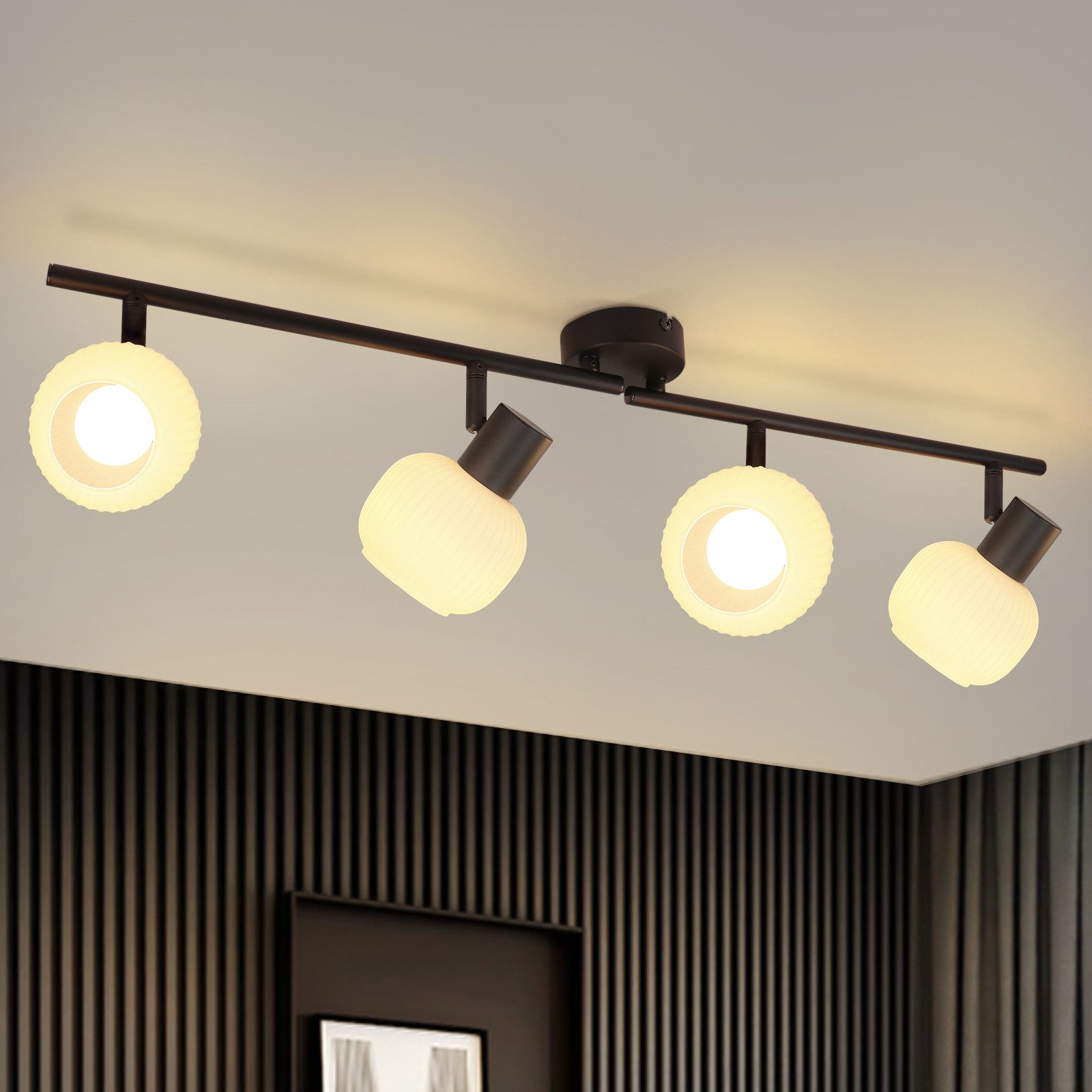 Cztery reflektory zamontowane na czarnym torze na suficie, oświetlające pomieszczenie.