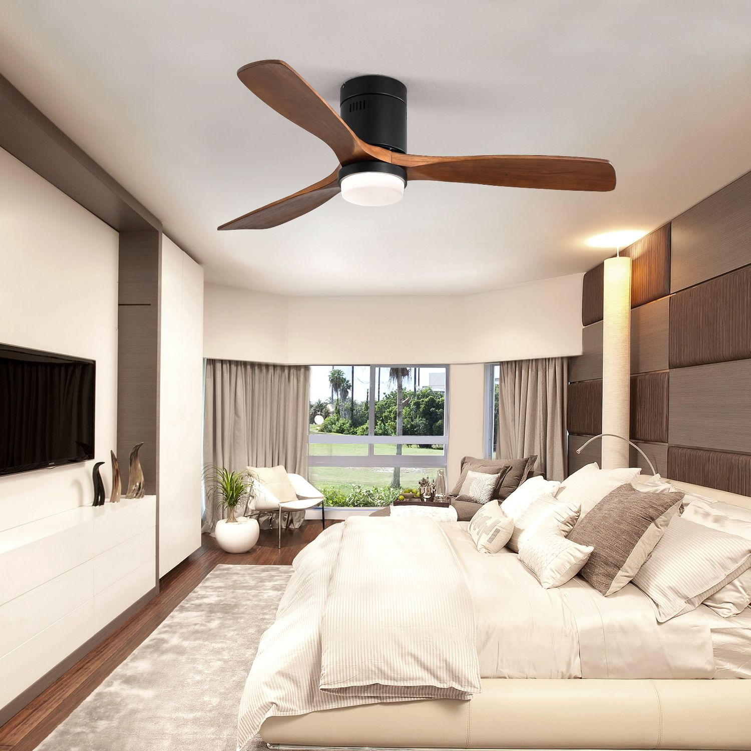 Schlafzimmer mit Deckenventilator, Bett und Fensterblick. Holzblätter und weiße Bettwäsche sichtbar.