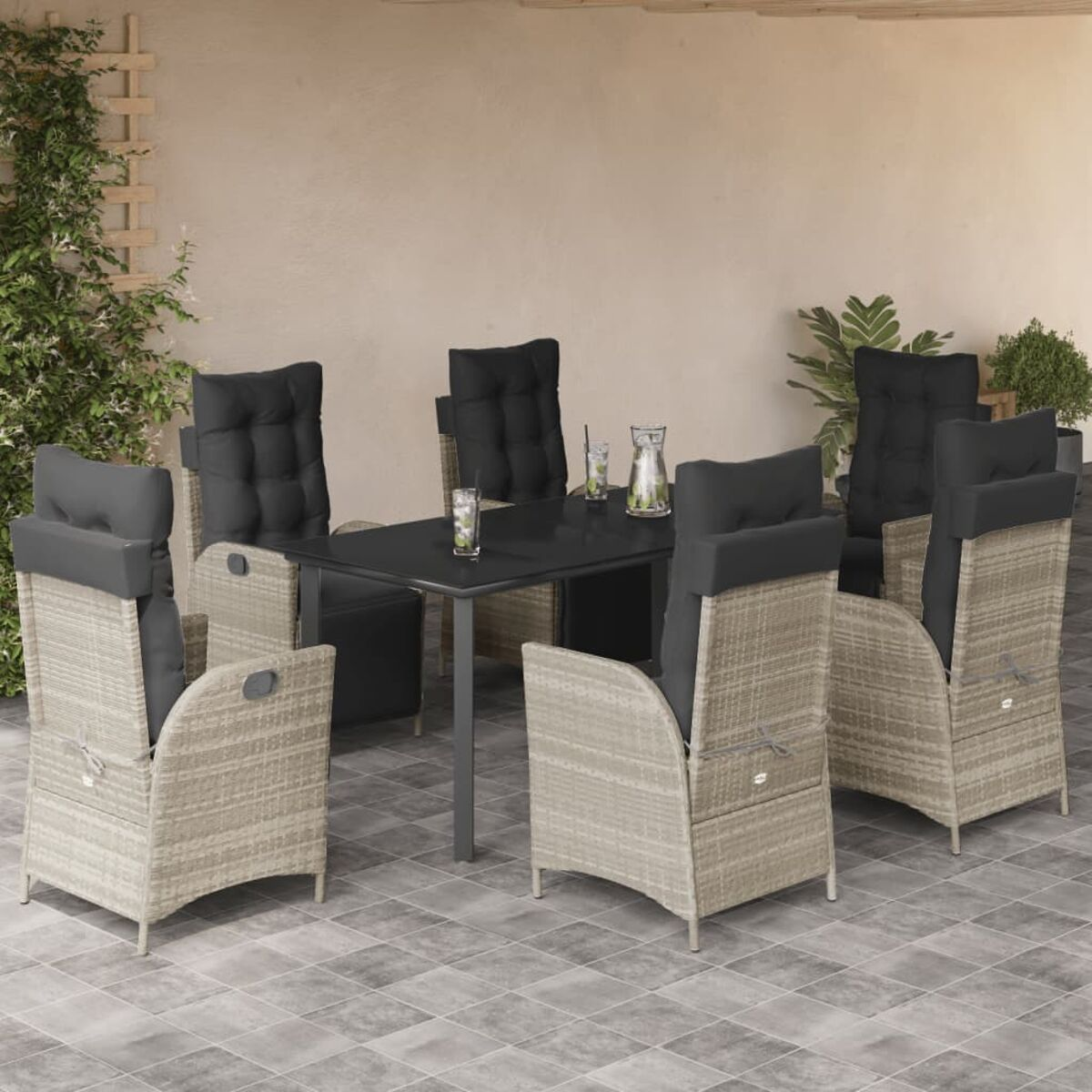 Set da pranzo all'aperto con cuscini neri. Tavolo e sei sedie su un patio.