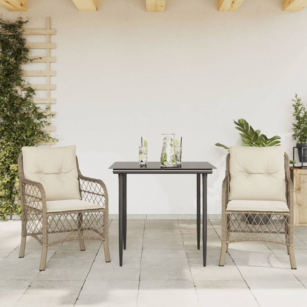 Outdoor-Terrassengarnitur. Tisch mit Stühlen und Getränken. Beige Kissen auf den Stühlen. Weiße Wand.