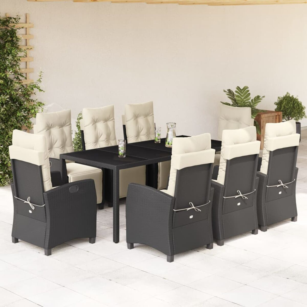 Essgruppe im Freien mit schwarzen gewebten Stühlen und dunklem Tisch, cremefarbene Kissen.