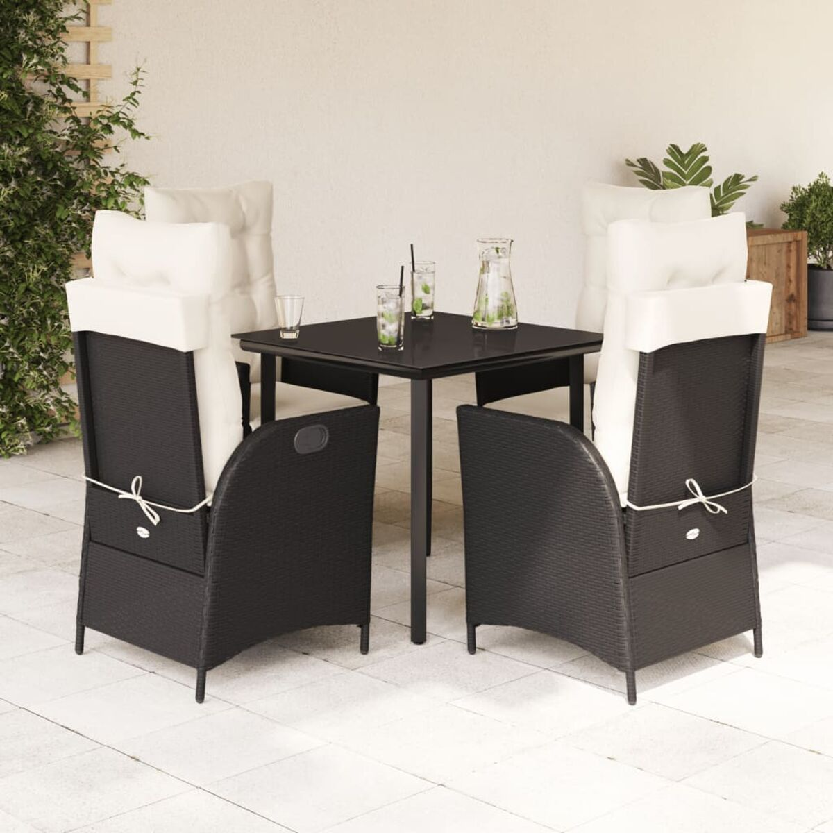 Set patio esterno: sedie nere, tavolo e bevande.