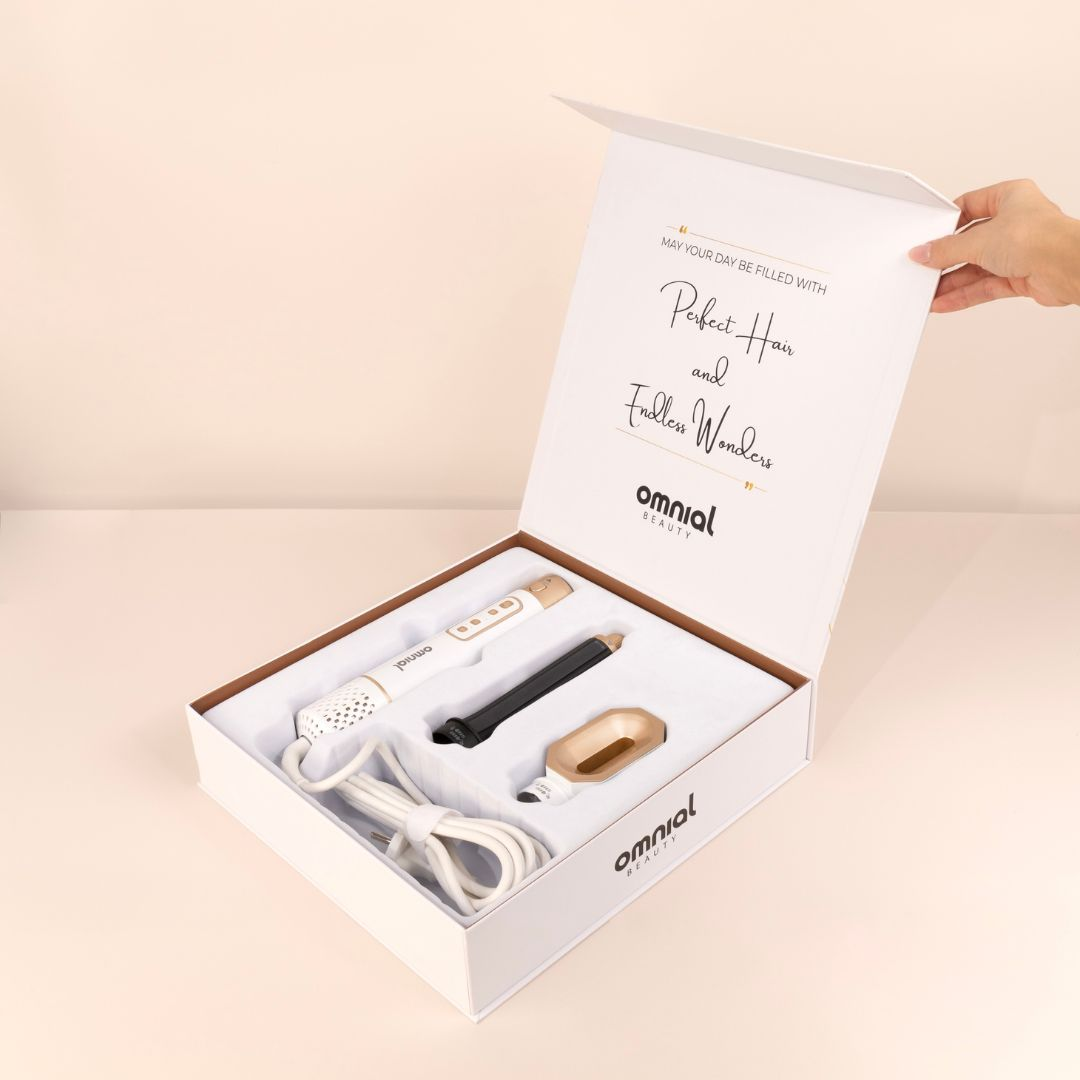 Box mit Schönheitsprodukten und Text. Enthält einen Lockenstab und andere Artikel.
