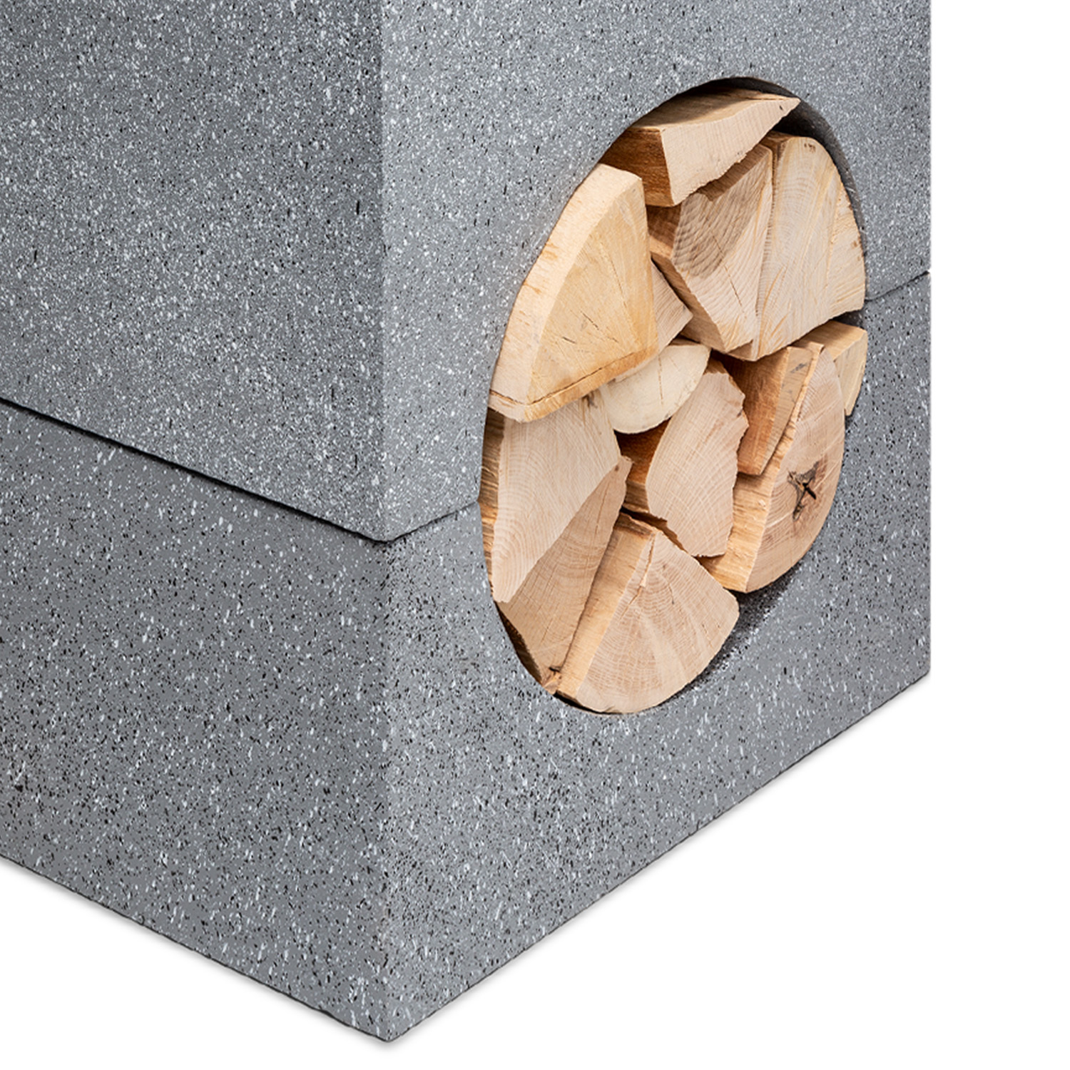 Grauer Betonblock mit runder Öffnung, gefüllt mit geschnittenem Brennholz. Das Holz ist hellbraun.