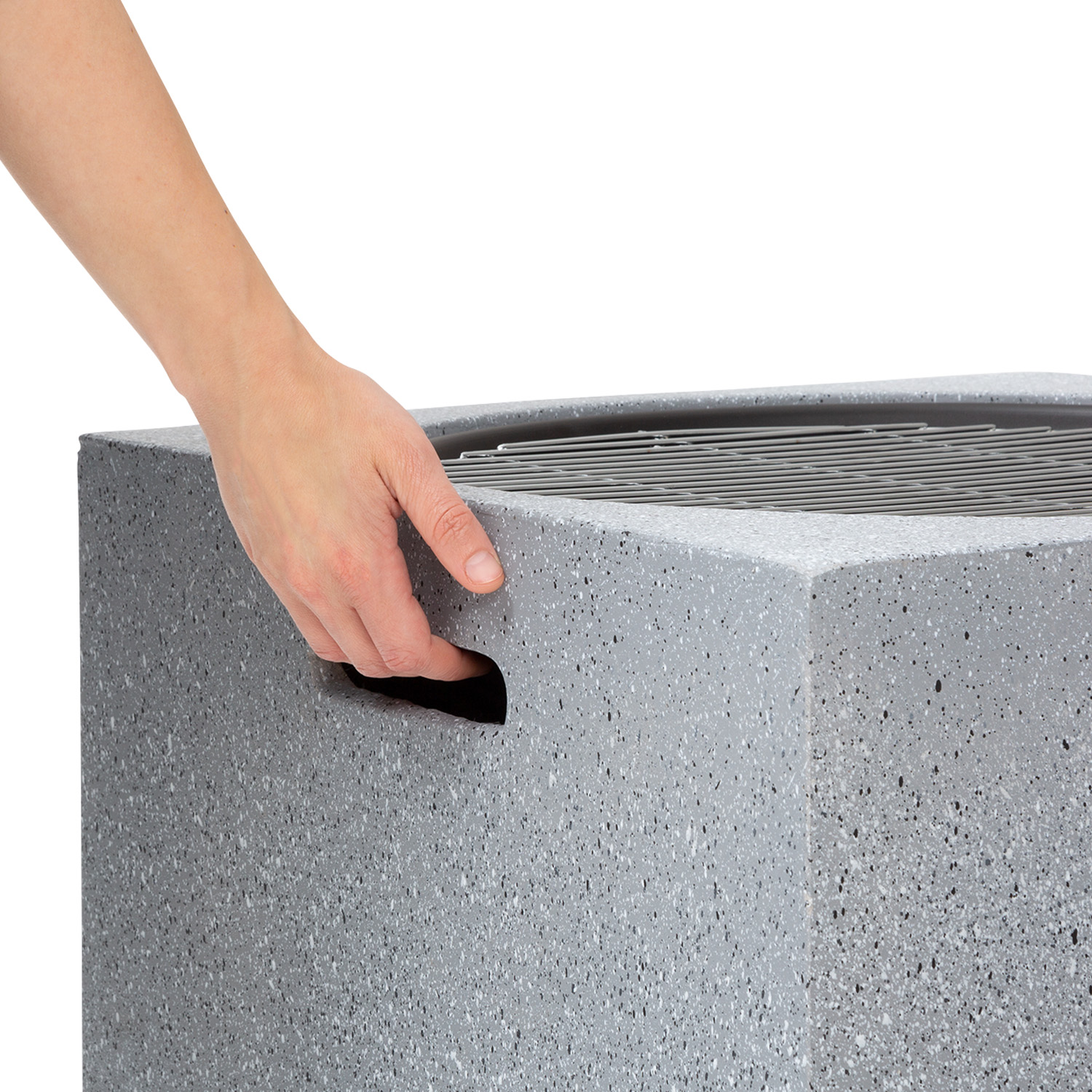 Eine Hand, die in einen grauen Würfel greift.